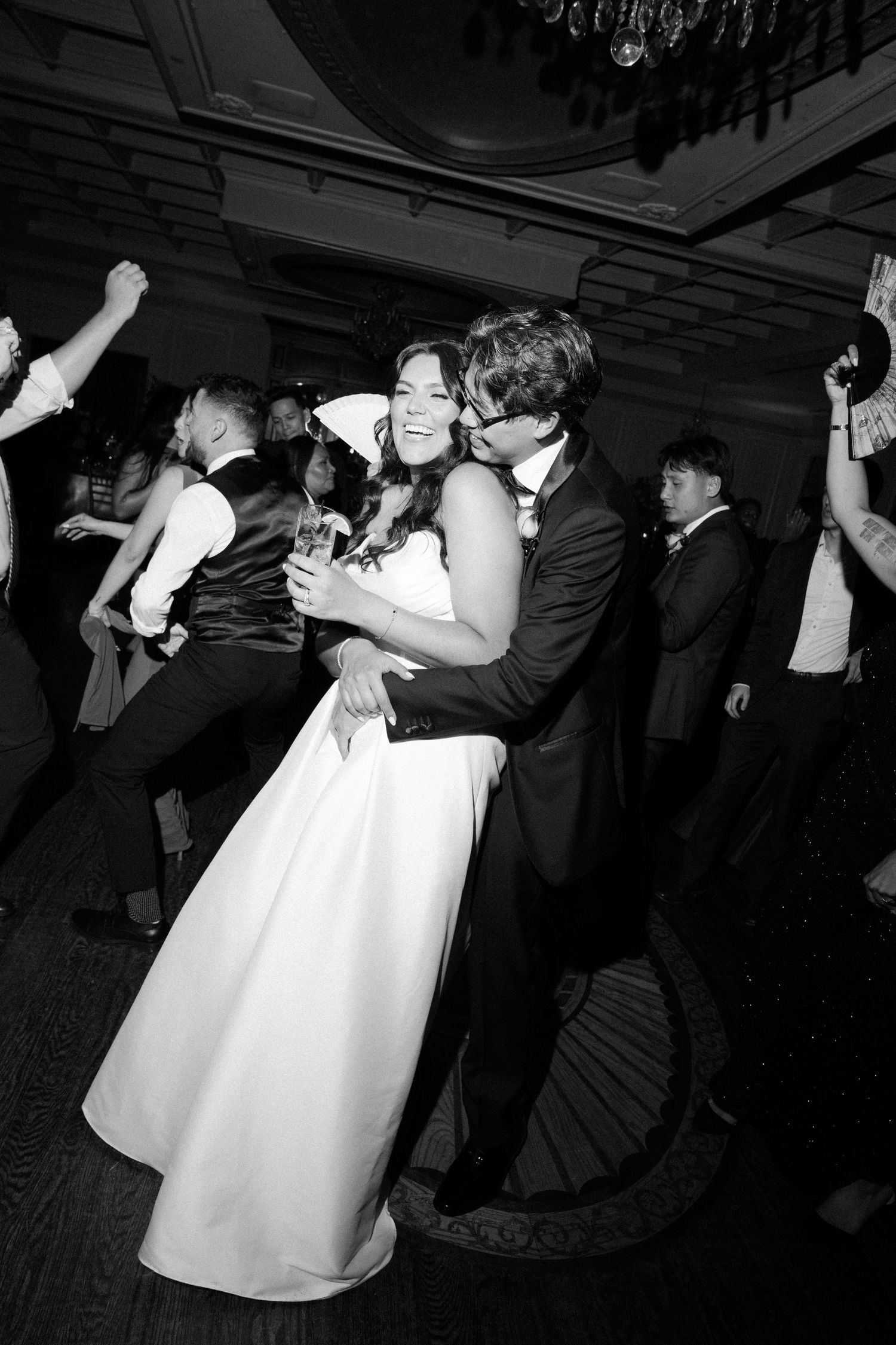 Black and white photos of wedding guests dancing energetically at a reception party.
