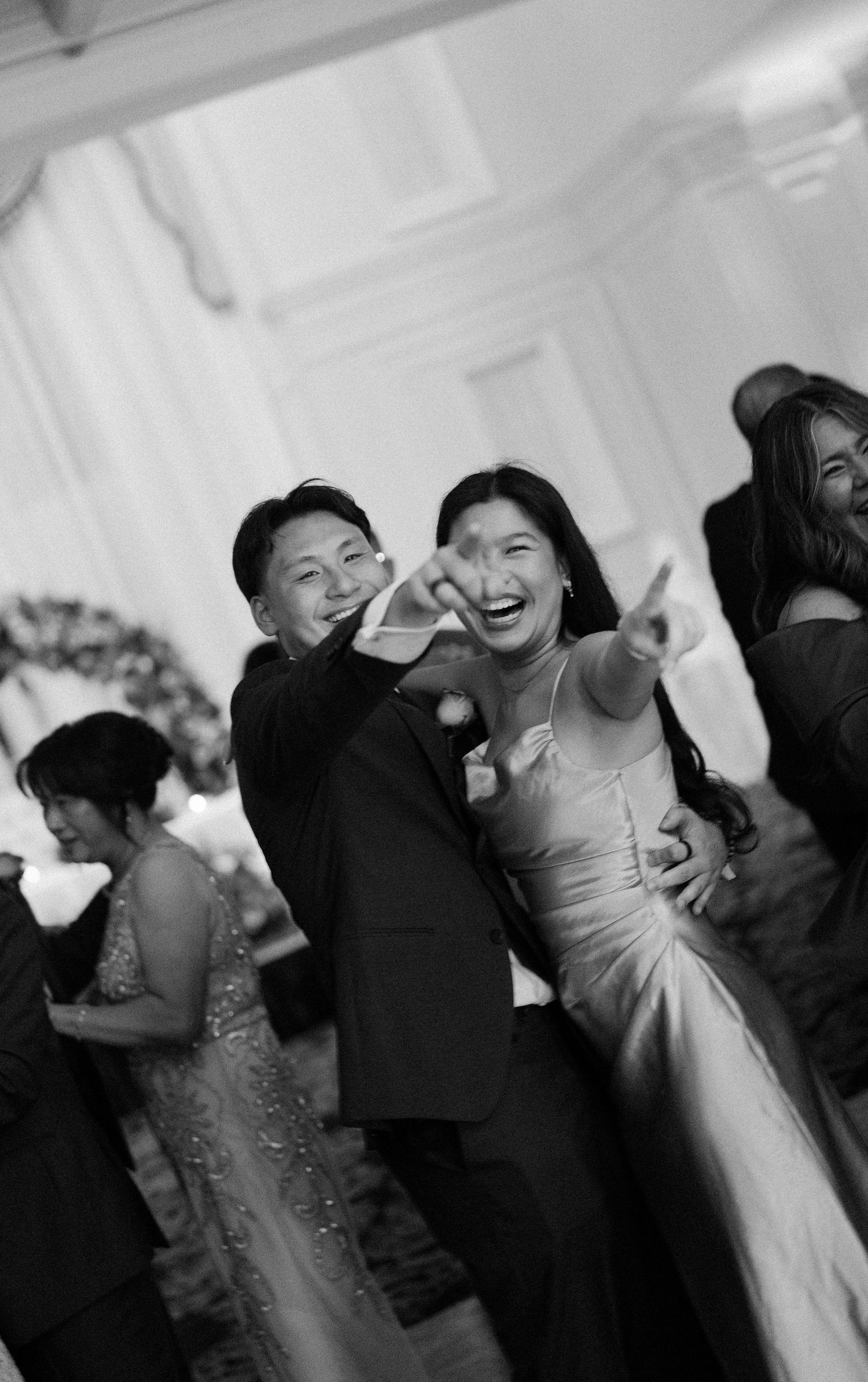 Wedding reception dance floor moments captured in black and white showing celebration and movement.