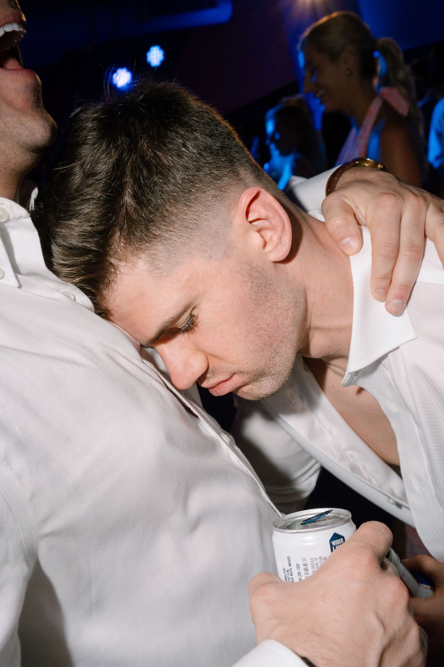 Close-up sequence showing someone in white shirt signing documents at a dimly lit venue.