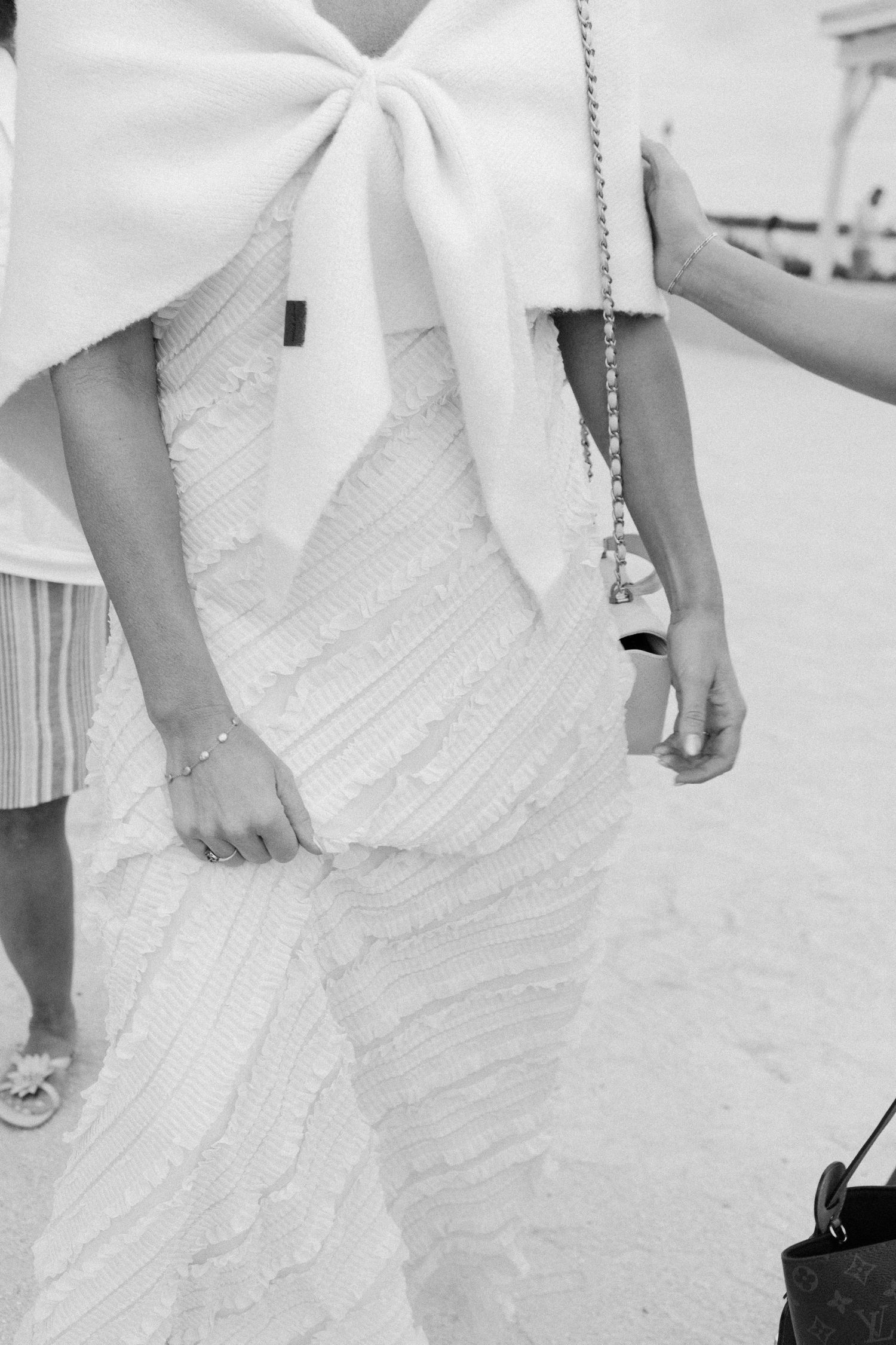 Close-up detail of a white wedding dress with a large bow accent.