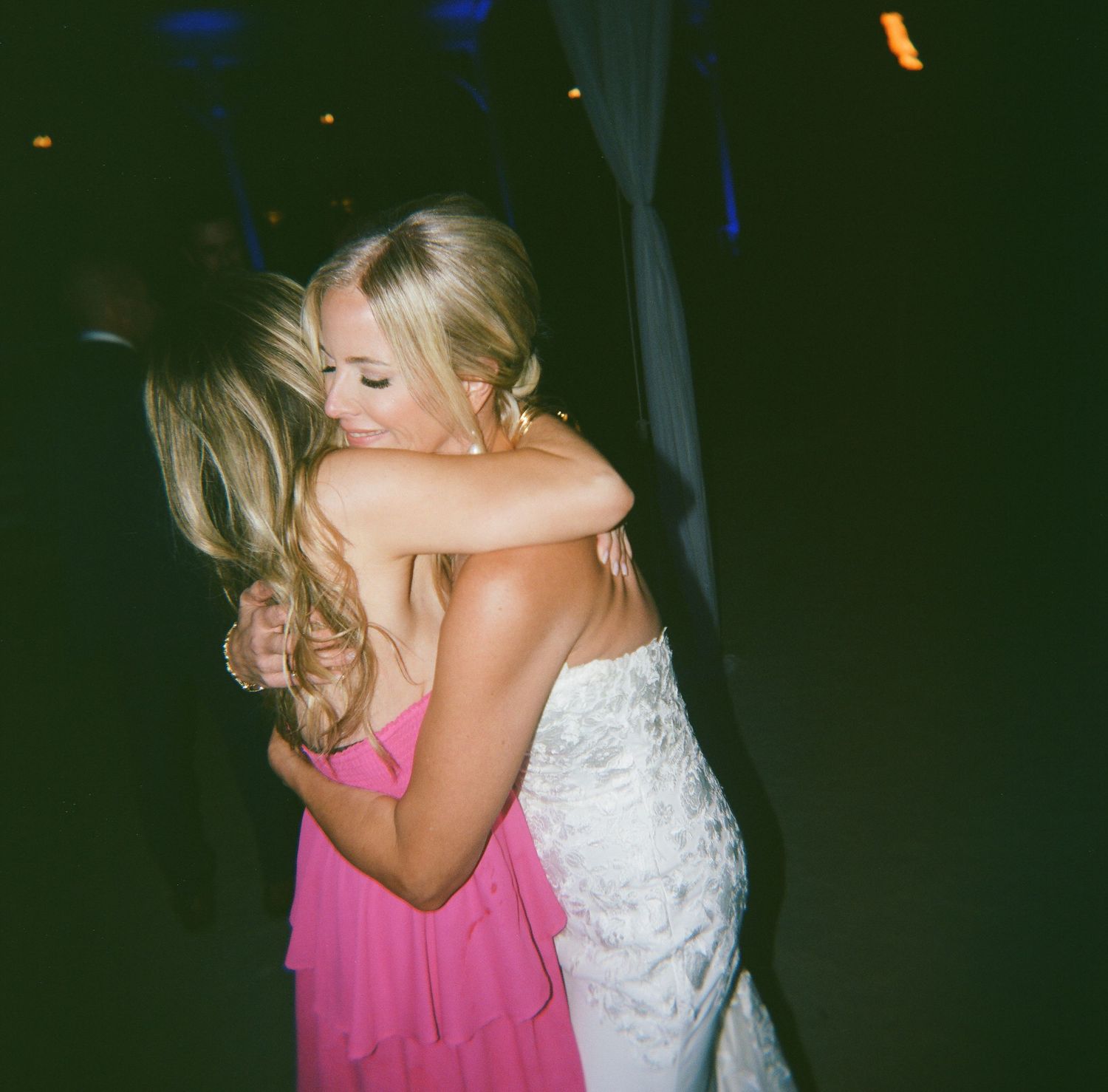Wedding guests embracing during an evening celebration.