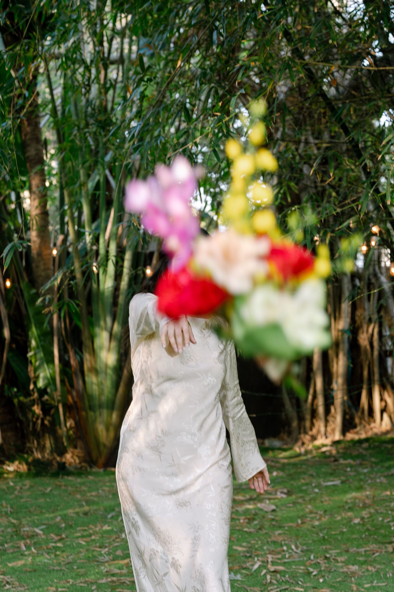 Flowing white dress movement captured in sequence against lush green garden backdrop with colorful flowers.