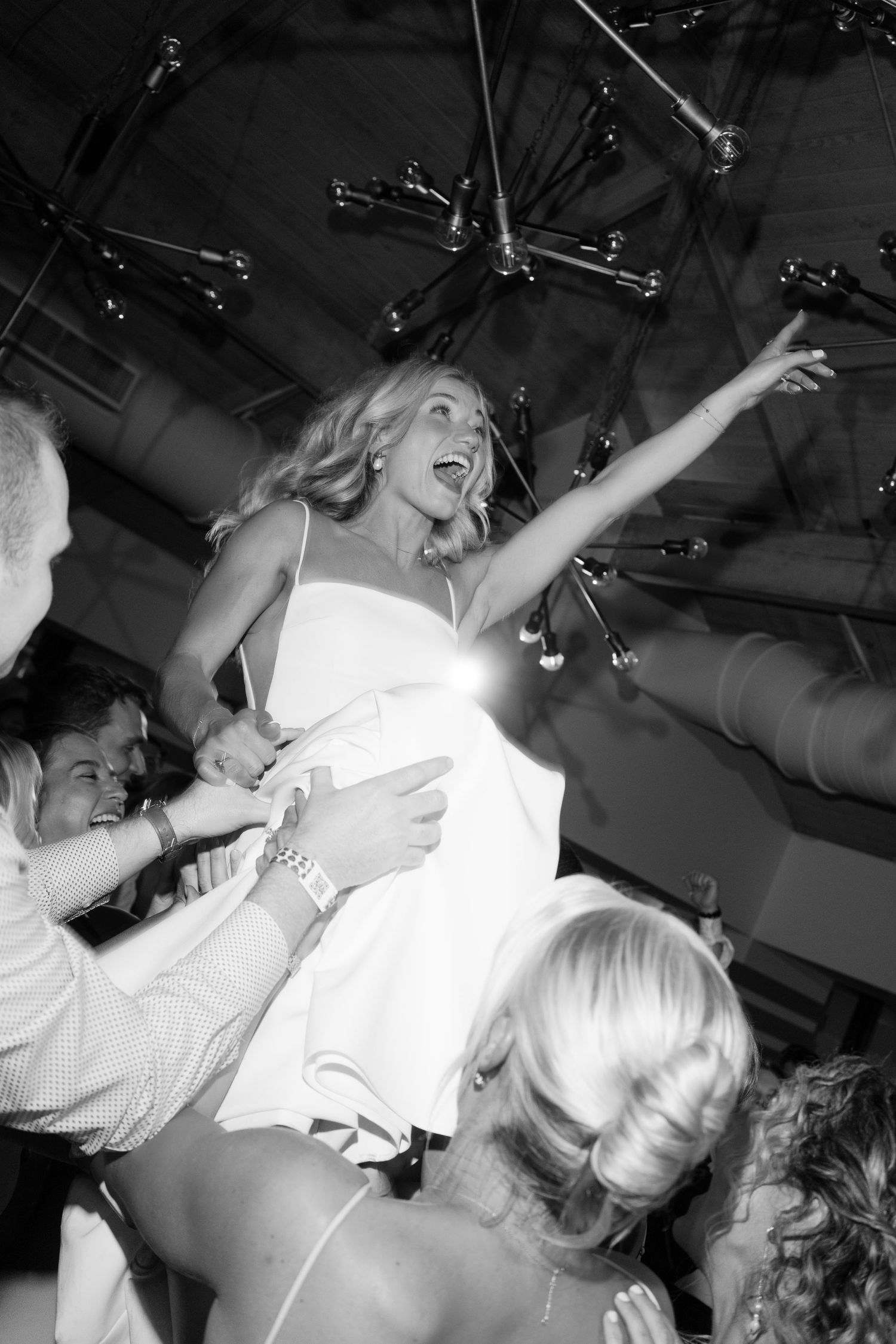 Black and white photos capturing energetic dancing moments at wedding reception.