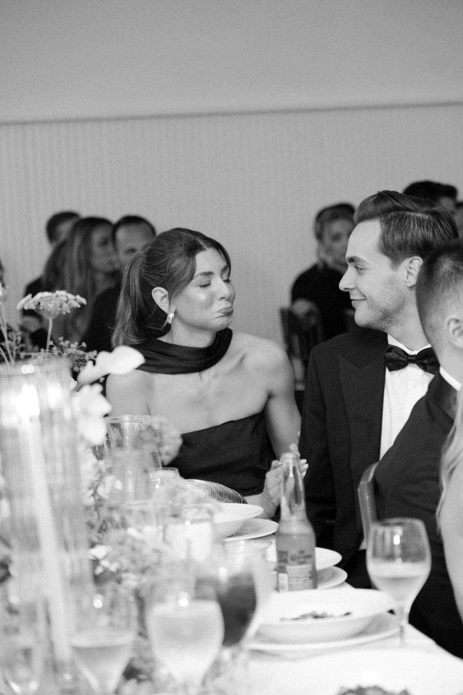 Black and white wedding reception photos showing guests dining and conversing at elegant tables with glassware.