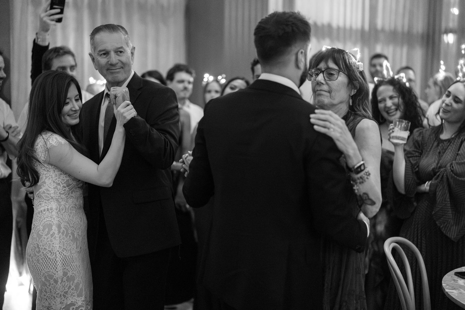 Wedding reception dance floor filled with guests in formal attire.