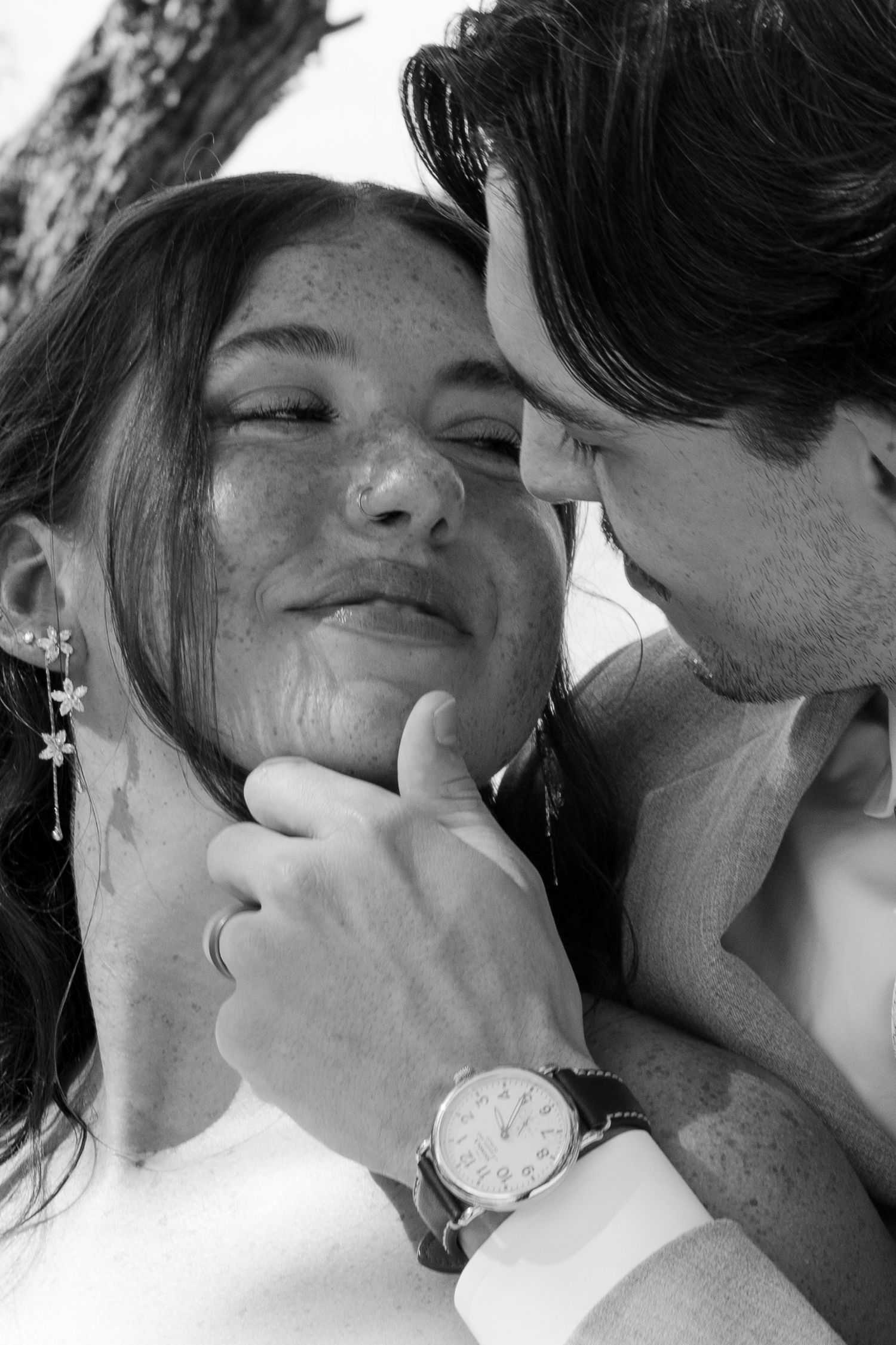 A black and white image showing a close-up of a couple embracing affectionately.