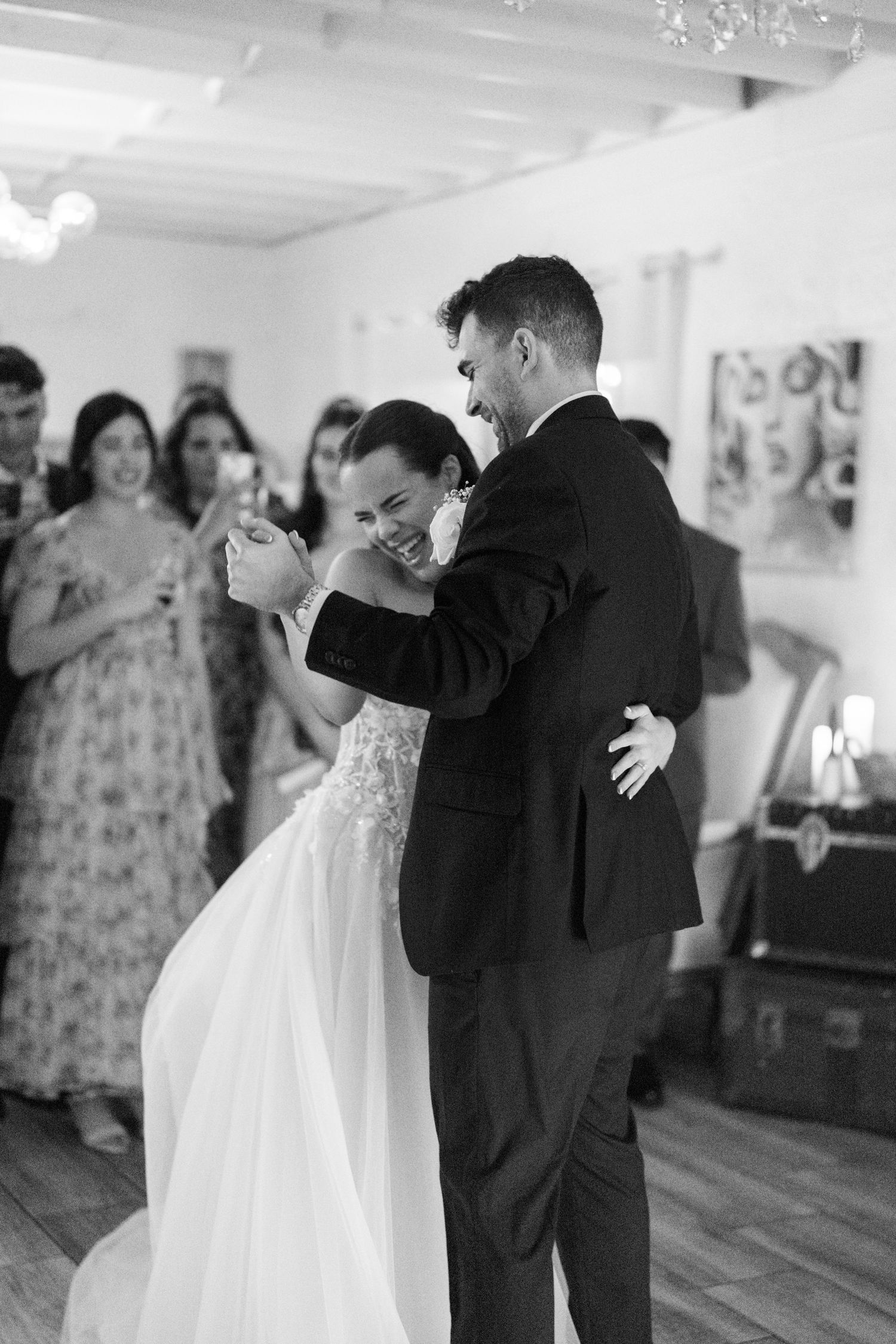 Bride and groom share their first dance in black and white at their wedding reception.