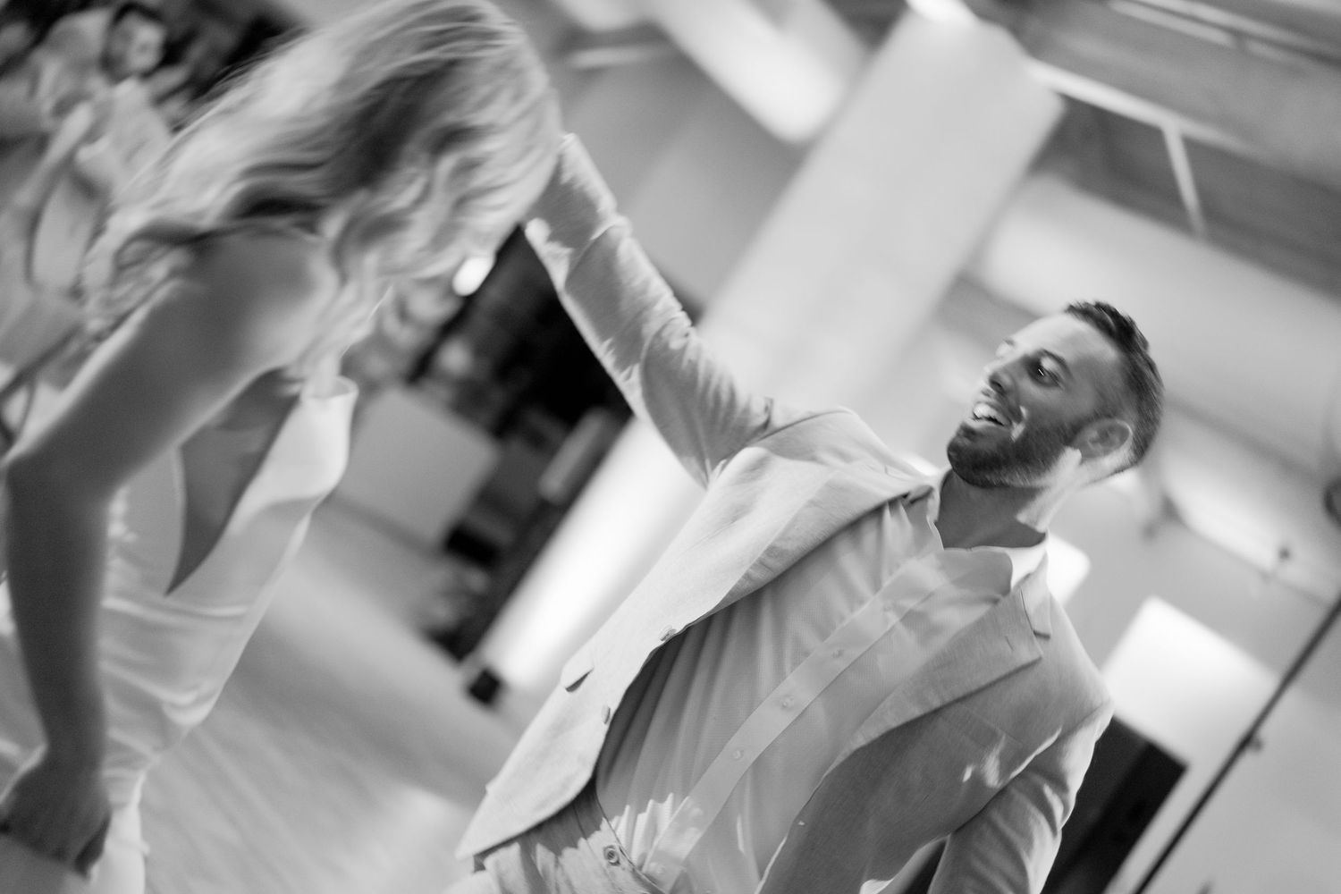 Black and white candid photo of a joyful dance moment.