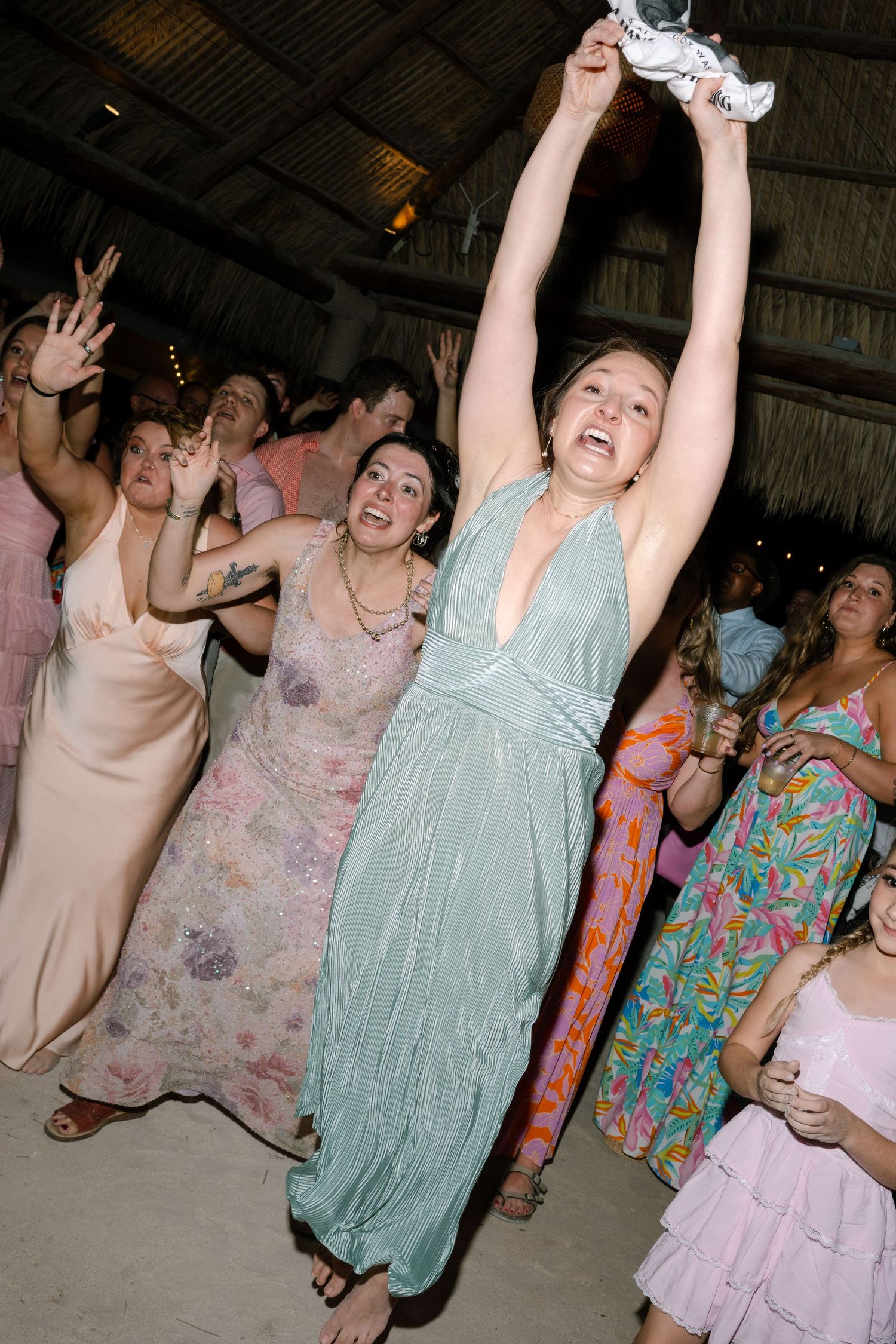 A group of women in colorful dresses dancing and celebrating at an event.