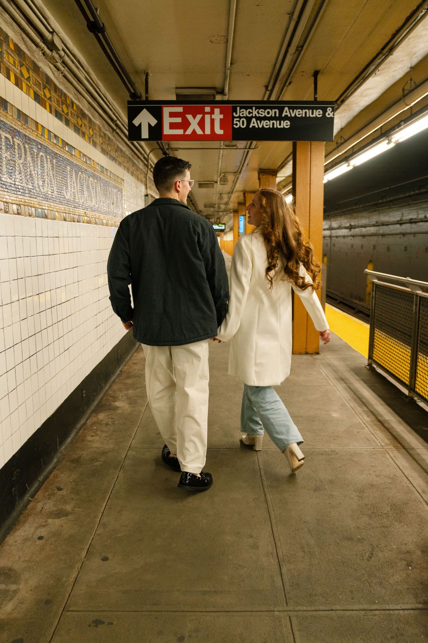 A couple explores the Jackson Avenue subway station platform in New York City.