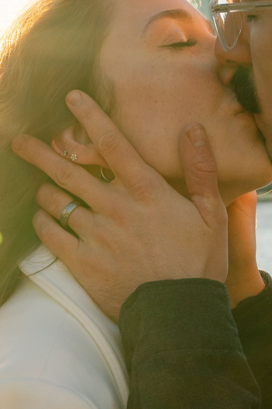 Close-up shots of hands with wedding rings in soft, romantic lighting.
