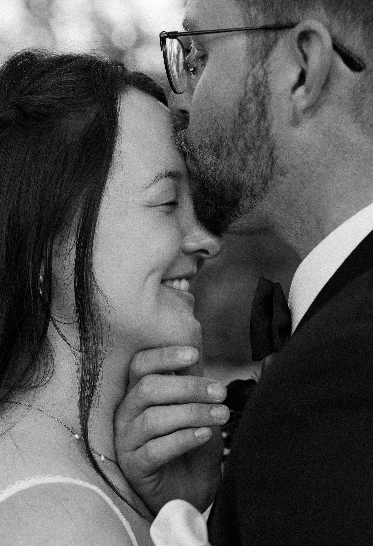 A romantic black and white photo series showing intimate close-up moments between a couple sharing tender kisses.