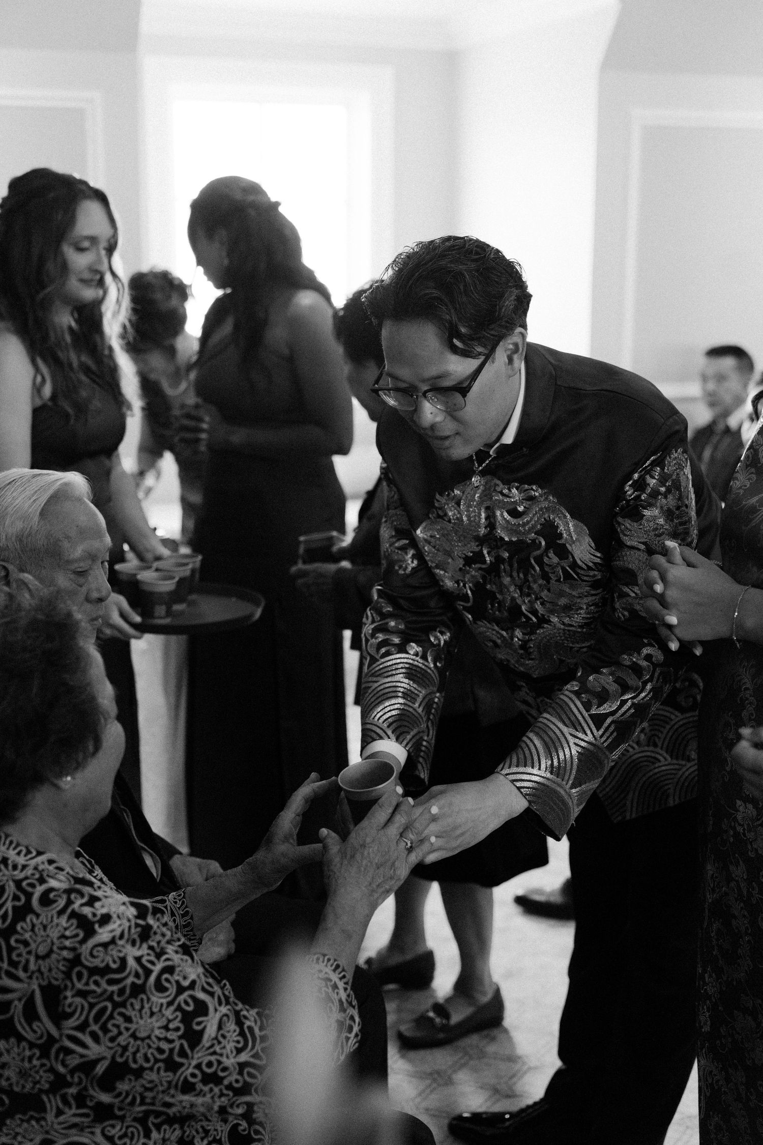 Black and white sequence of wedding reception dancing in an elegant indoor venue.