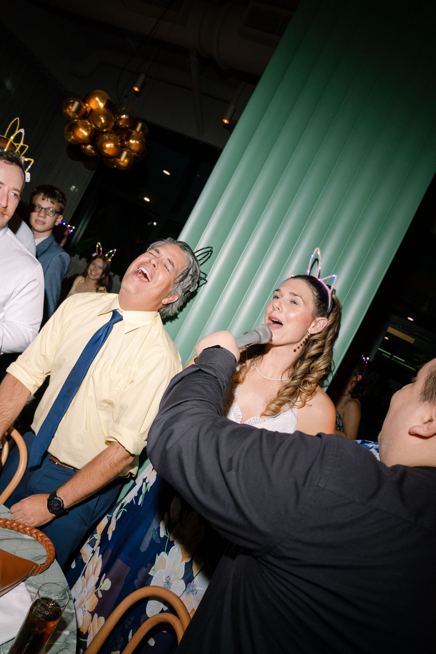 Group of wedding guests laughing and enjoying themselves at a reception party.