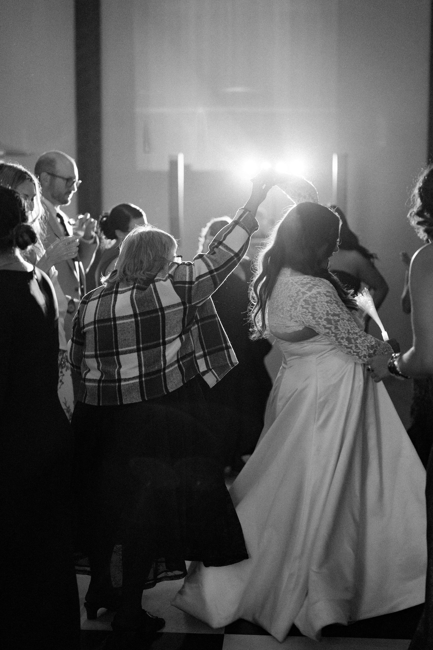 A group of people dancing at a formal event in a black and white photograph.