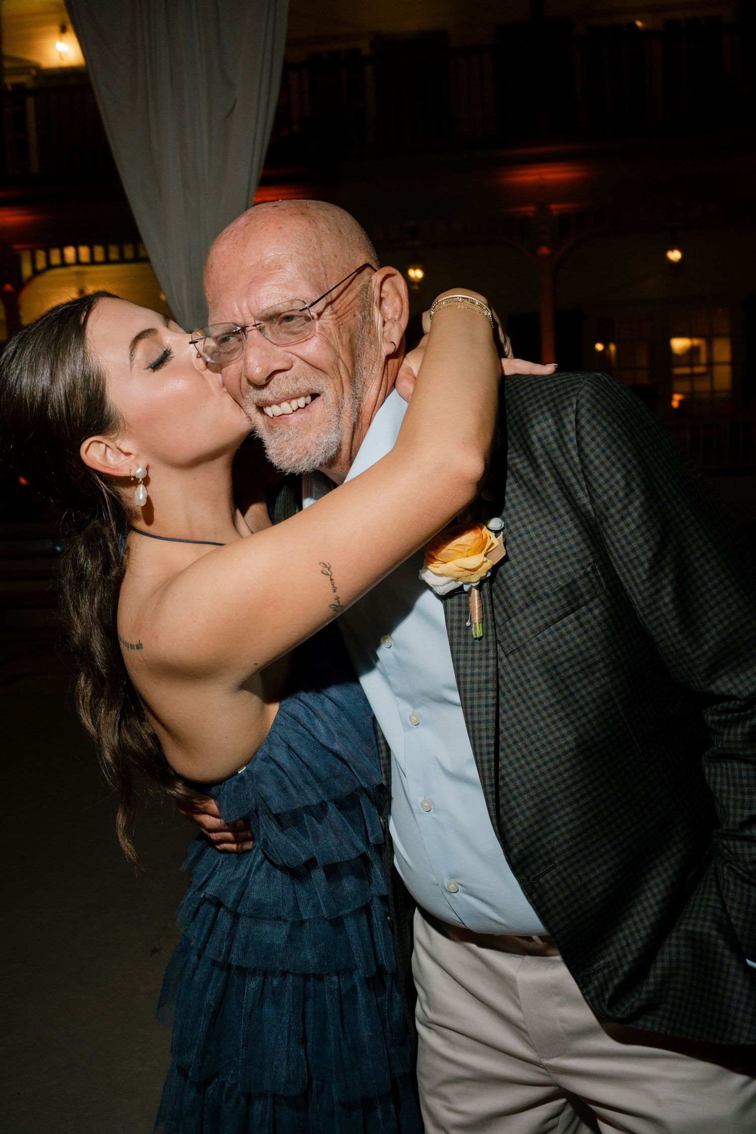 Sweet moment shared between guests during an evening celebration with warm ambient lighting.