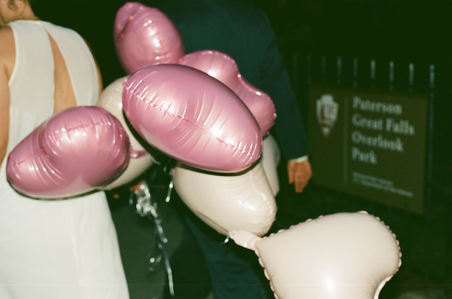 Pink heart-shaped balloons floating in a dark setting with gentle illumination.