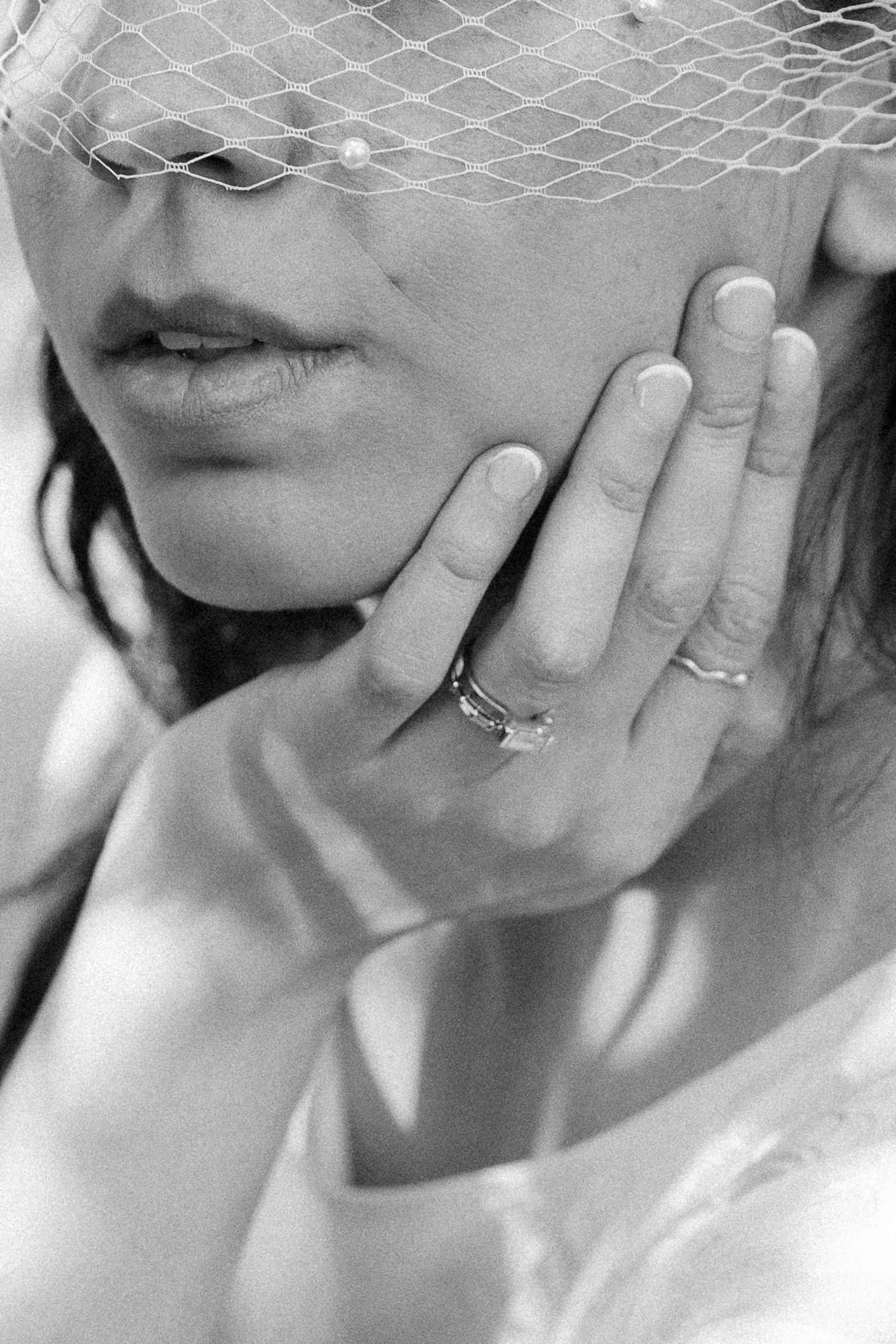 Black and white photo series showing close up shots of hands touching faces with engagement rings.