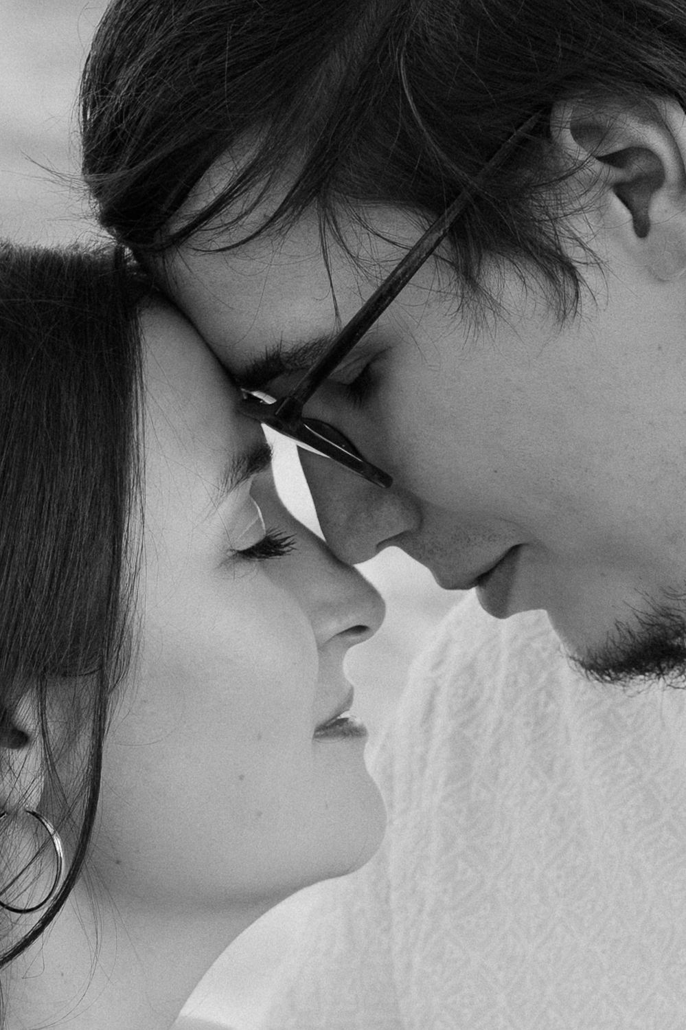 A black and white close-up profile view of a romantic couple about to kiss.