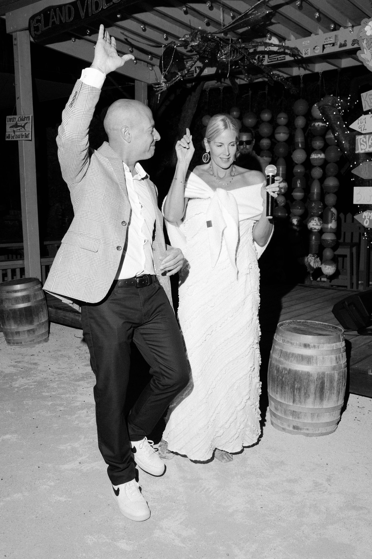 Four sequential black and white photos show dancers performing energetic moves near wooden barrels.