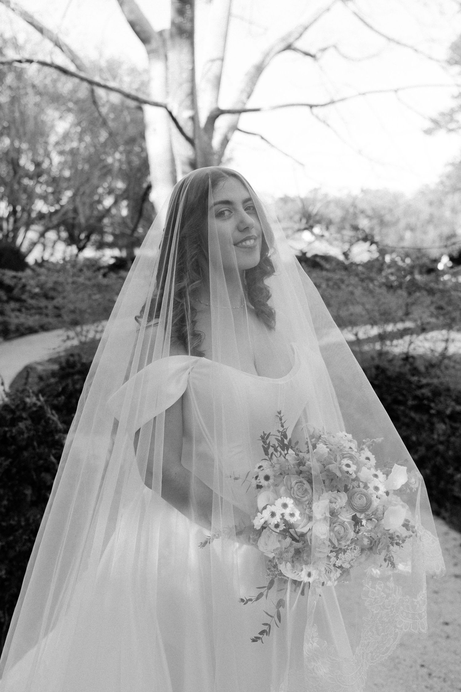 A sequence of black and white bridal portraits showing a woman in a wedding veil holding a delicate floral bouquet outdoors.