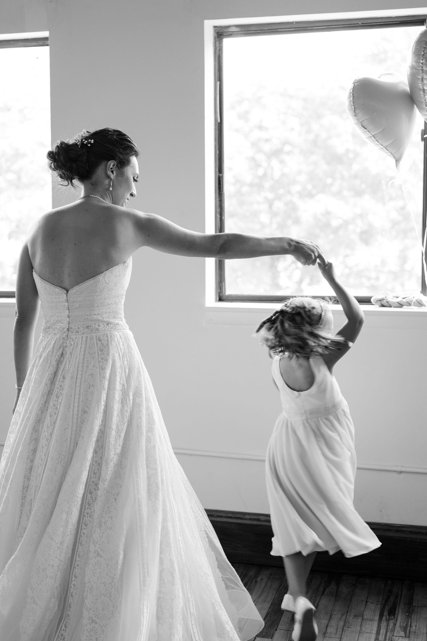 Multiple shots of figures in white dresses twirling and dancing in a bright sunlit room.