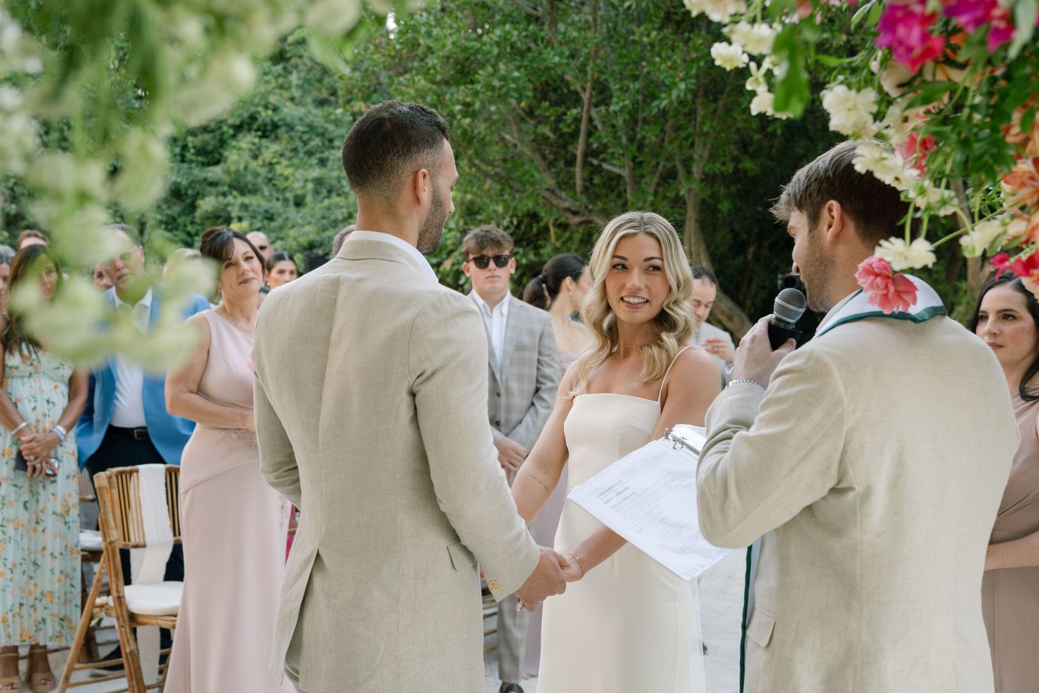 Wedding celebration in a garden setting with guests and natural greenery.