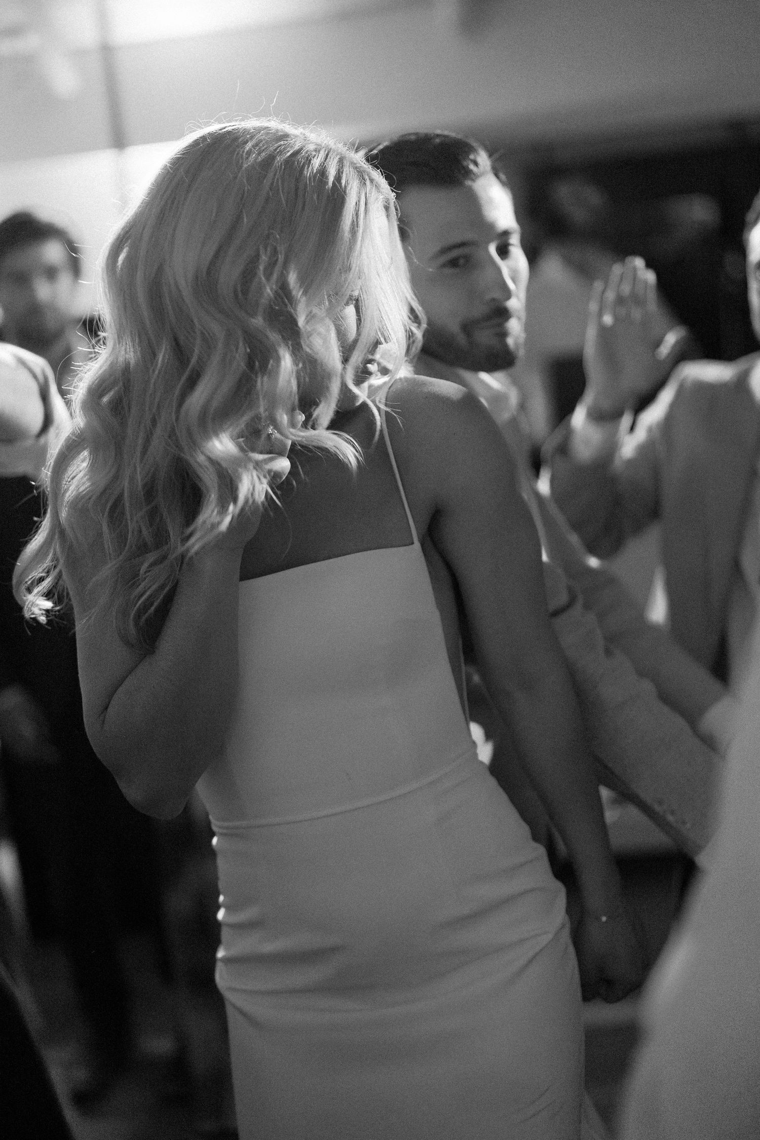 Black and white candid shots of wedding guests dancing at the reception.