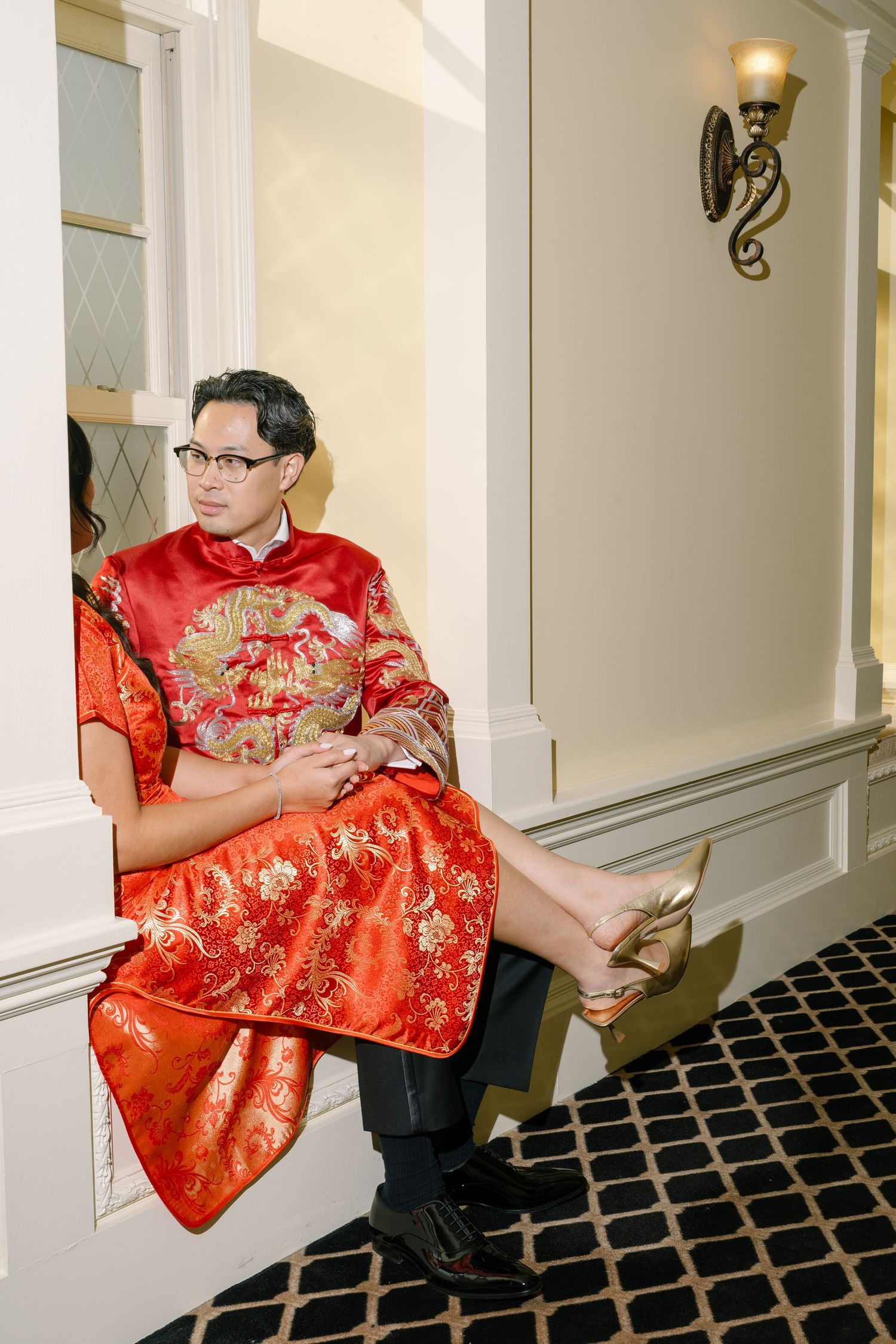 A sequence of someone wearing a red traditional Chinese silk robe reading a document in an elegant hallway.