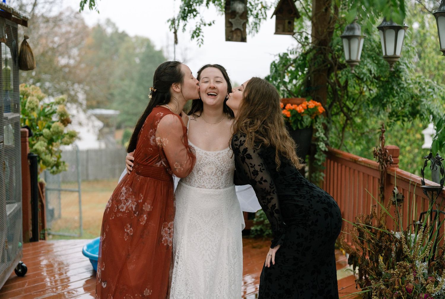 Wedding celebration with guests under hanging lanterns in an outdoor garden setting.