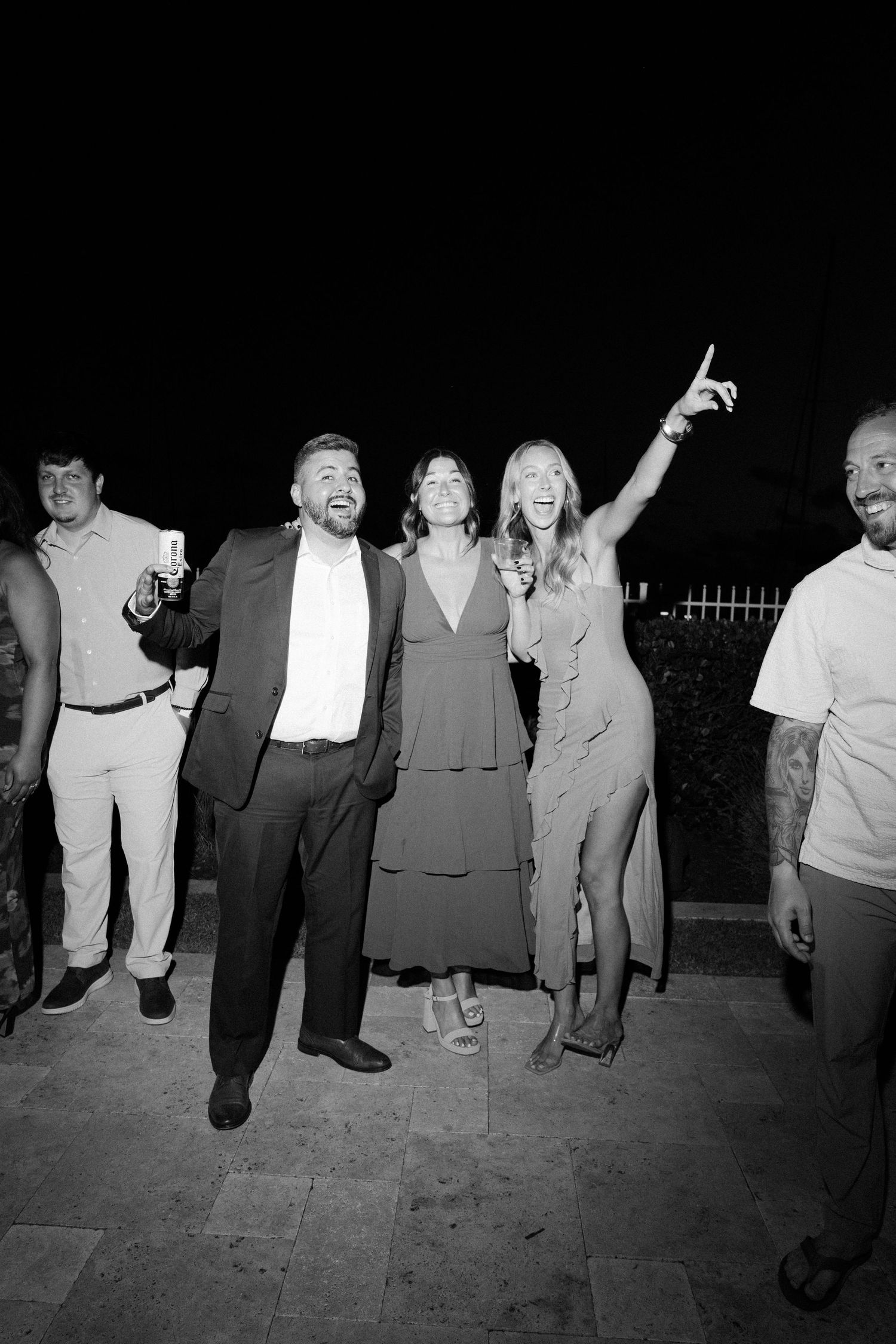 Black and white photo showing a line of people dancing at a party.