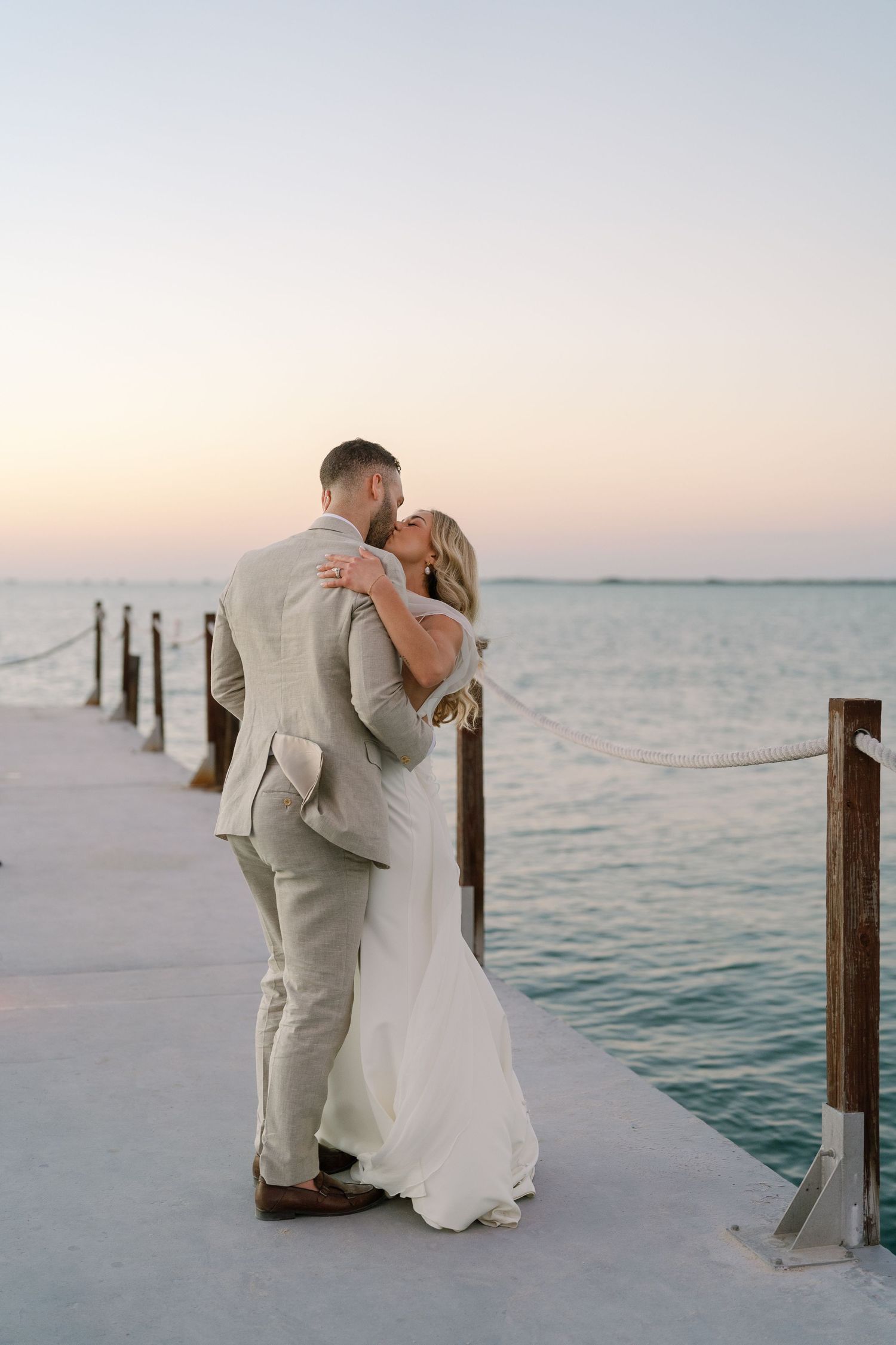 Romantic sunset moment on a seaside dock with ocean views.