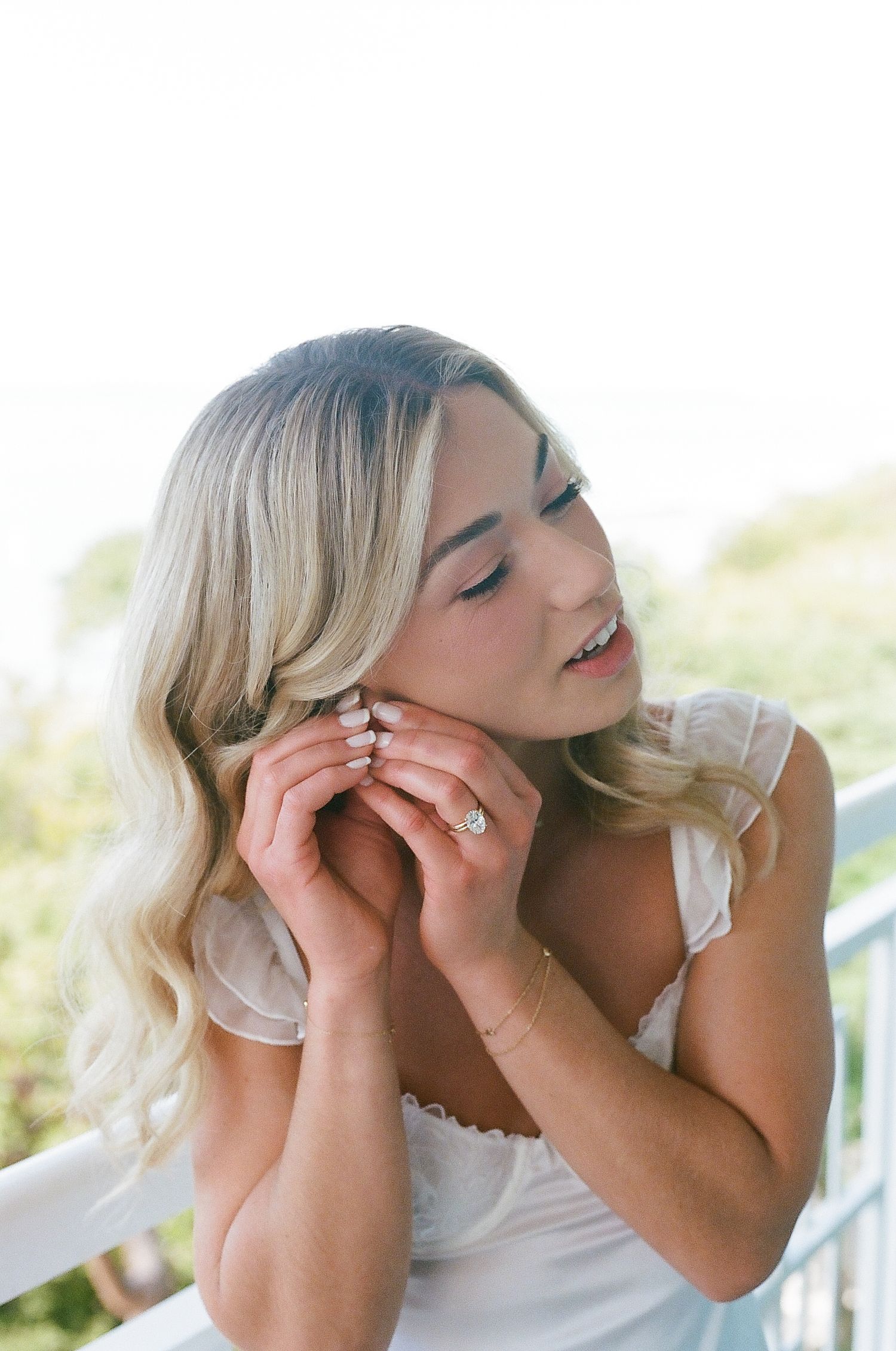 Close-up sequence showing someone putting on delicate earrings in soft natural lighting.