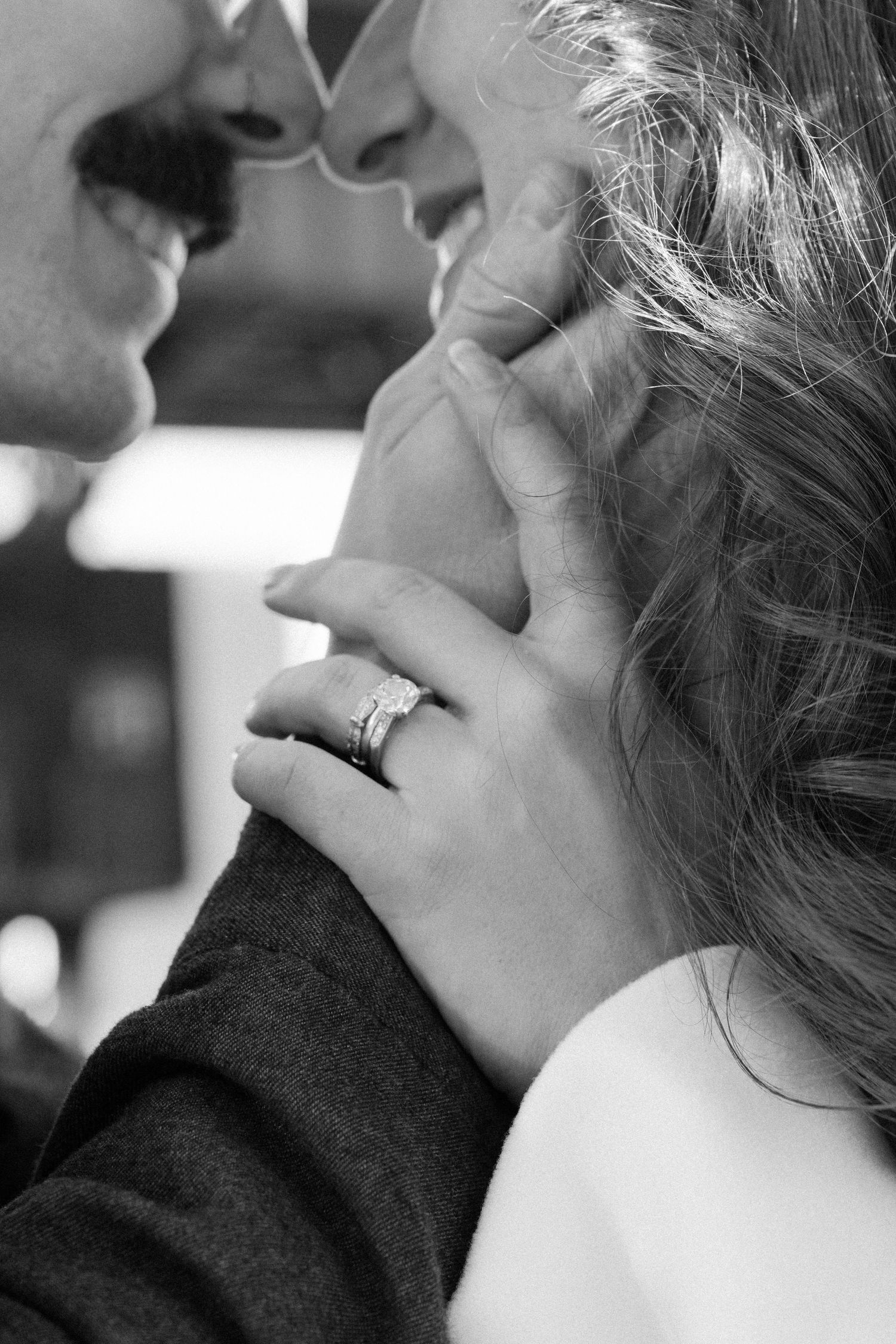 A close-up black and white shot of a tender romantic moment between a couple.