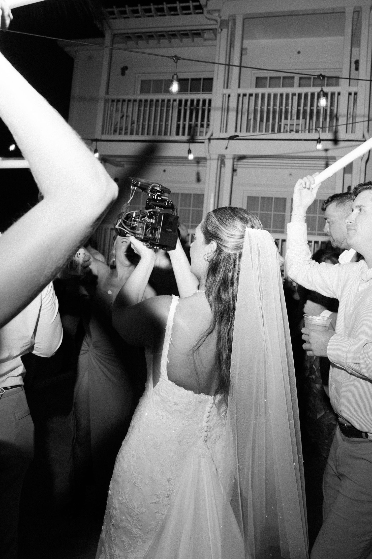 A wedding celebration captured in black and white with a photographer taking pictures.