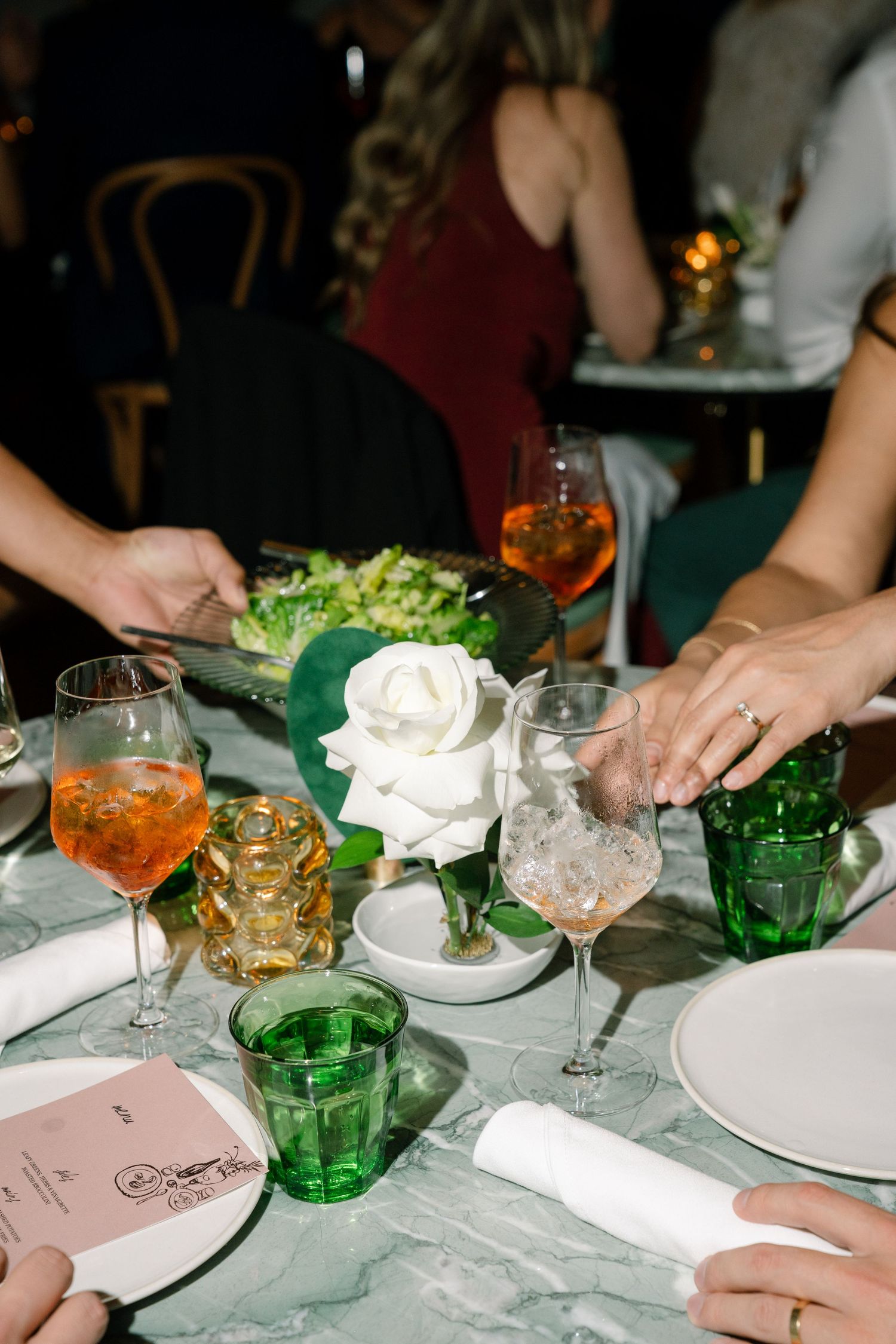Elegant table setting with green glassware and white napkins at formal dinner event.