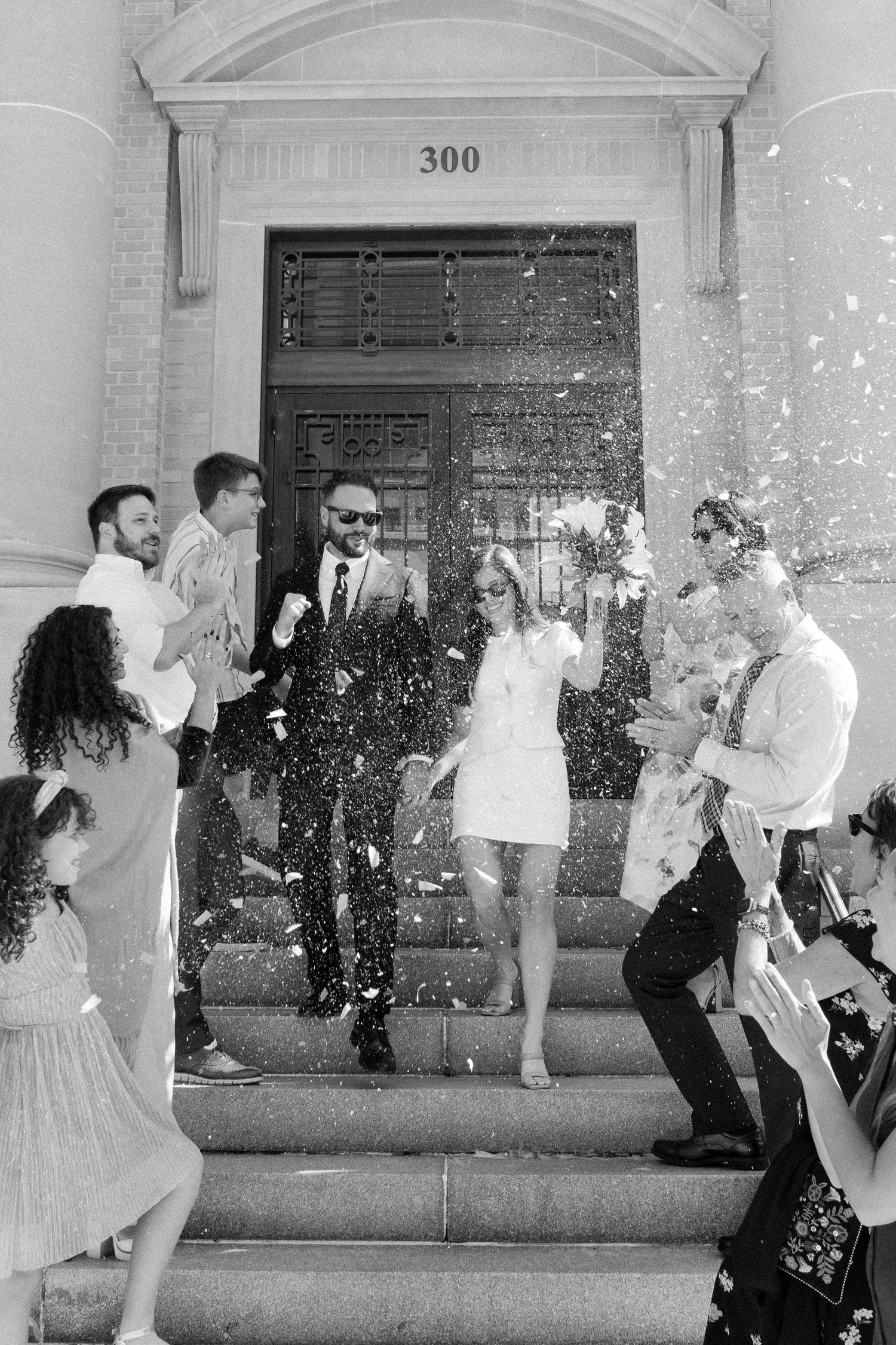 A sequence of black and white photos showing couples dancing in front of a building entrance with columns.