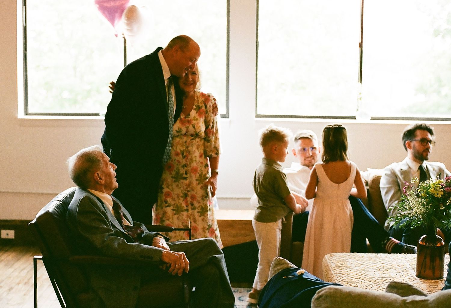 A collage strip of candid moments from a wedding reception showing guests mingling and socializing in an indoor venue.