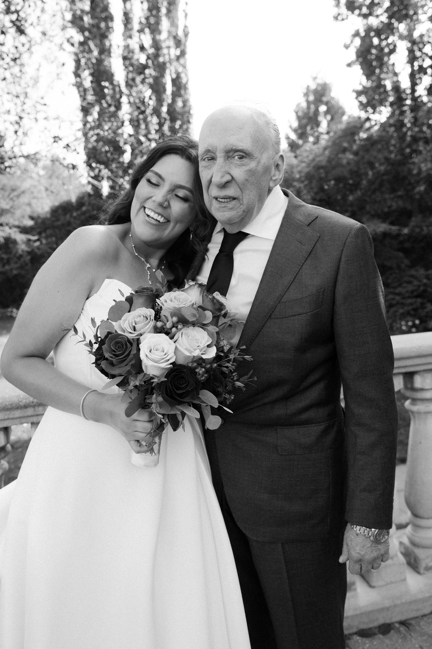 Black and white wedding photos showing tender moments between a bride and groom outdoors.