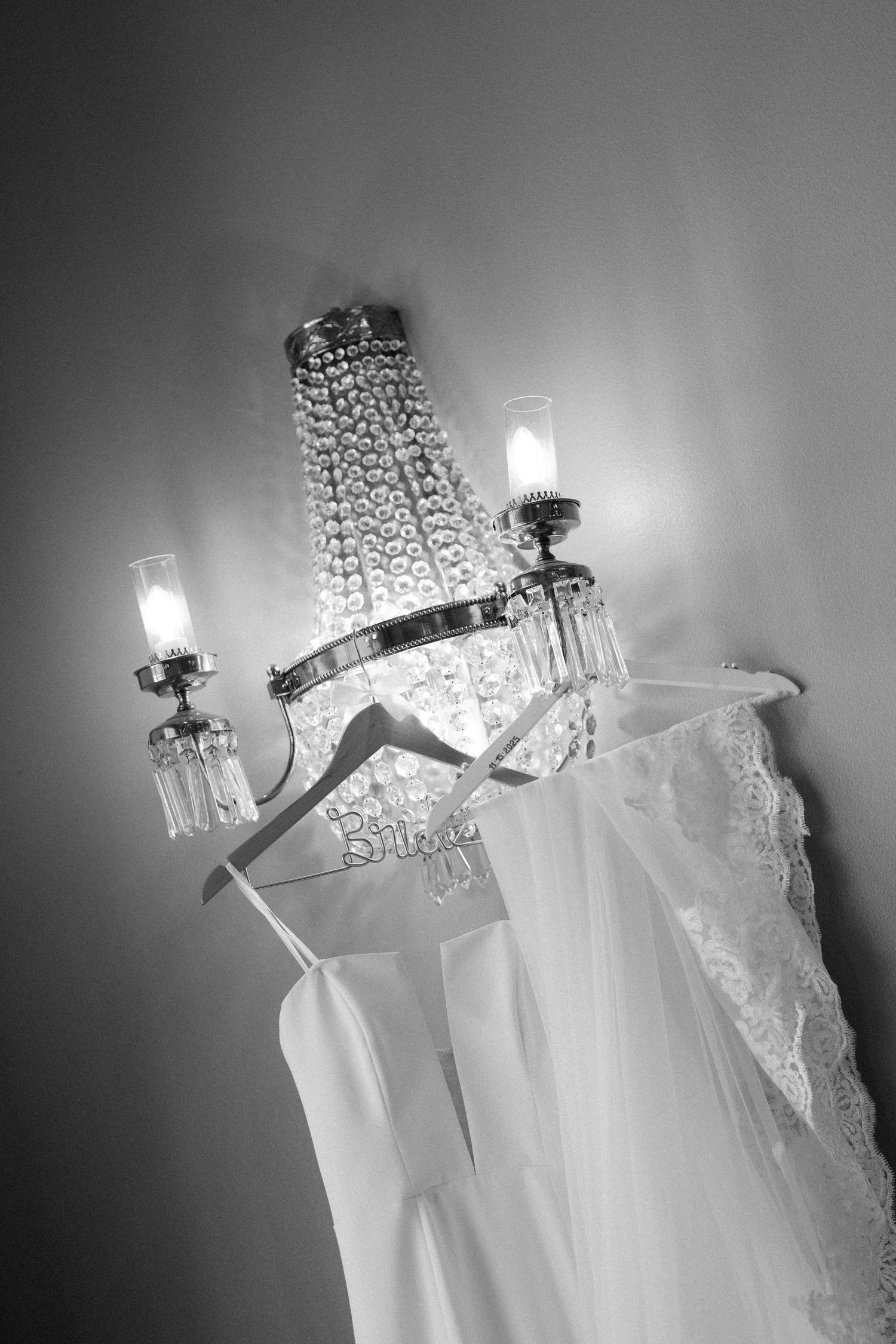 Wedding dress hangers with crystal embellishments displayed against a grey background.