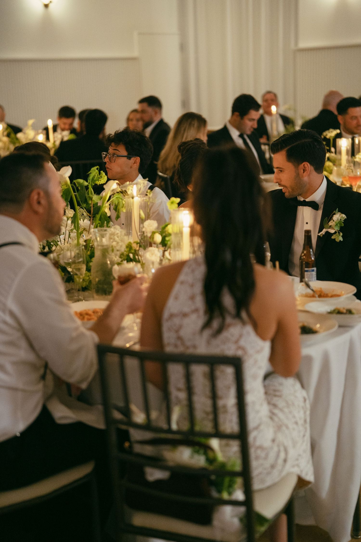 Elegant wedding reception dinner with candlelit tables and floral centerpieces.