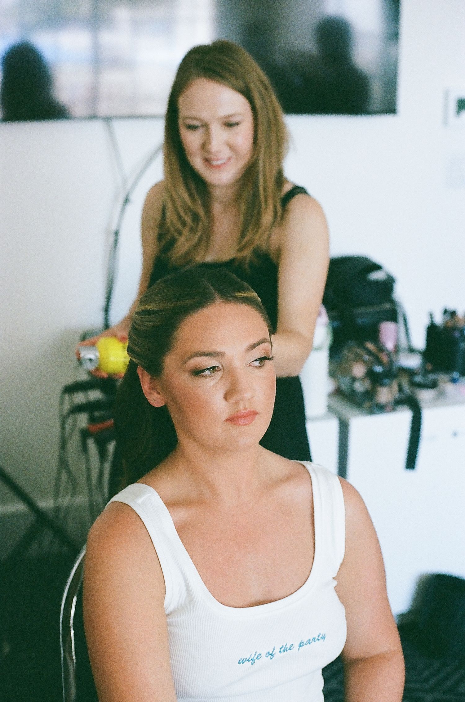 A series of candid getting-ready photos showing a person in a white tank top during wedding preparations.