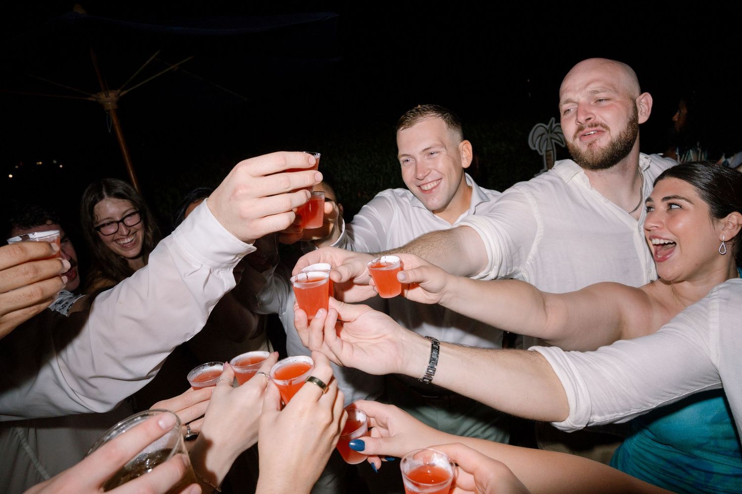 A sequence of motion photos showing hands passing a small orange object between people at a social gathering.