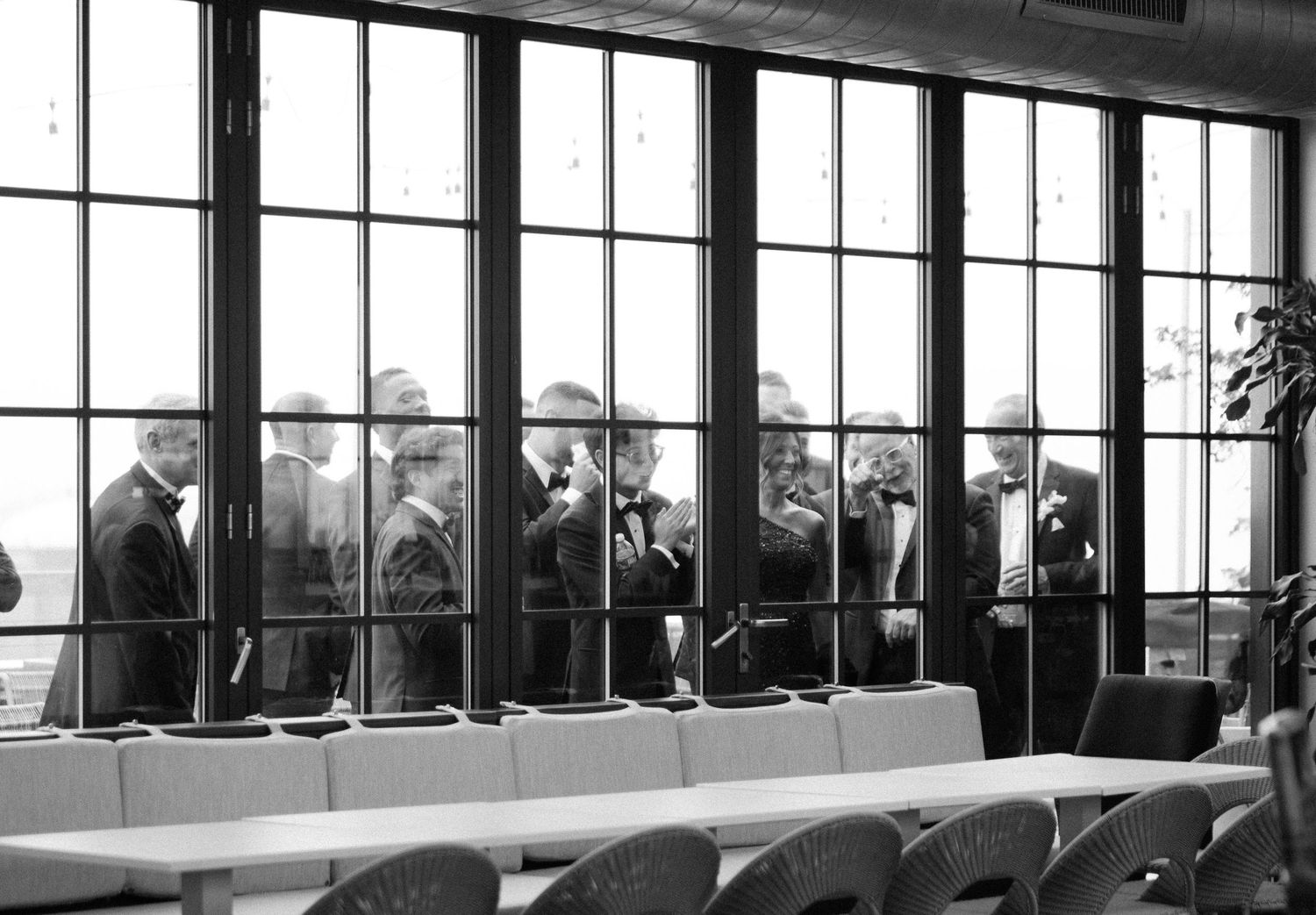 Black and white panoramic view of a modern event space with floor-to-ceiling windows.
