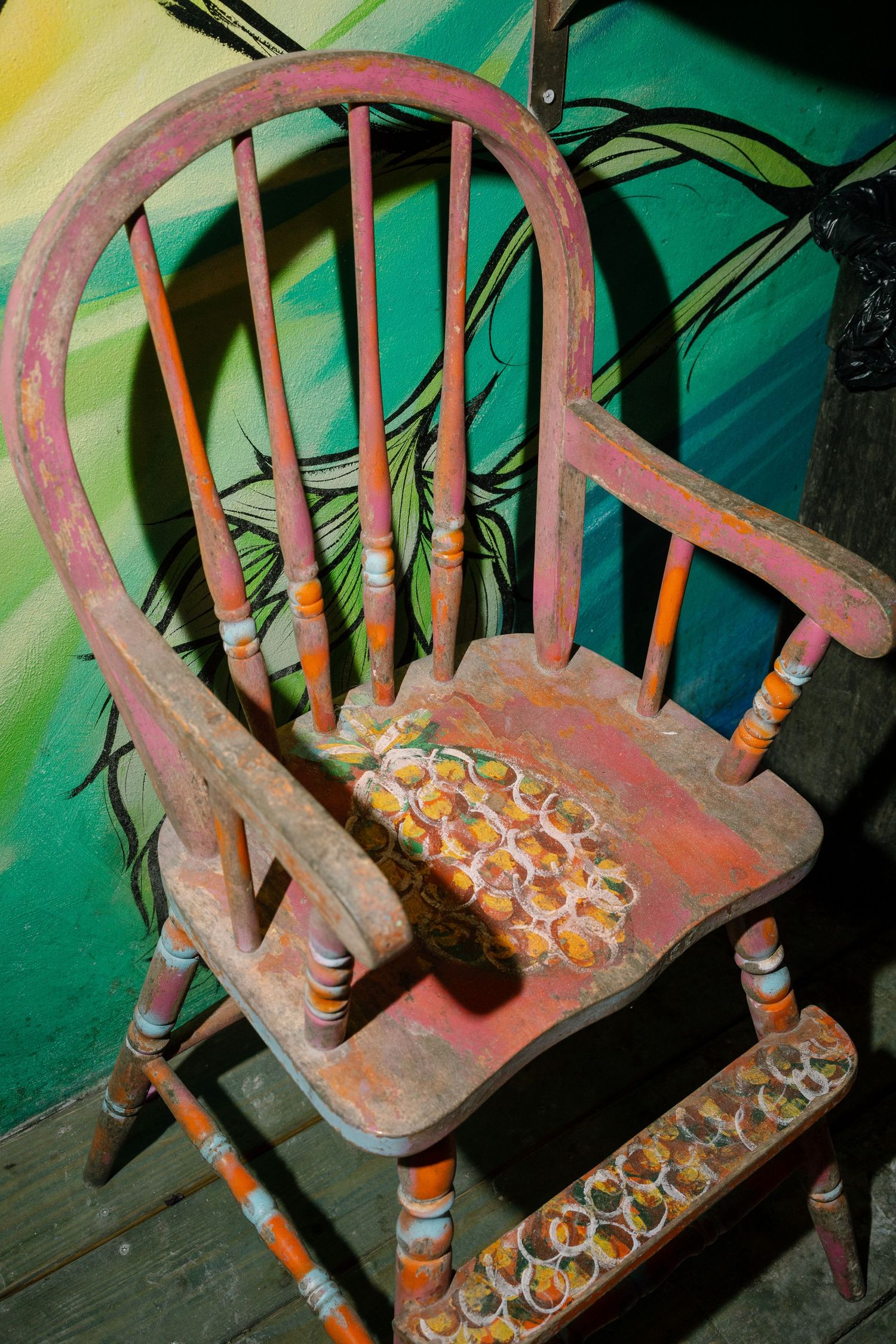 A sequence showing cigarette butts being arranged in a decorative pattern on a wooden chair seat.