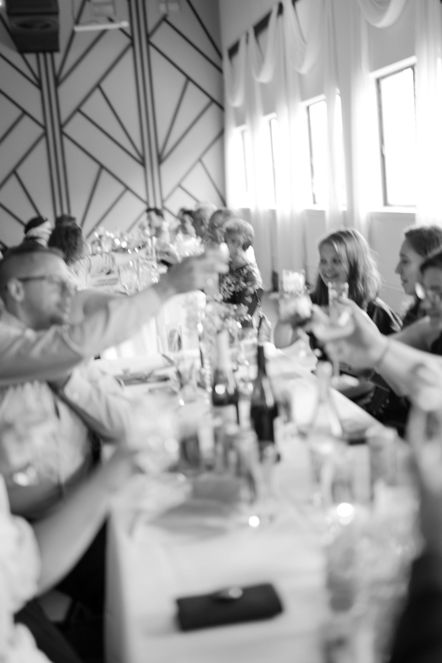 Black and white reception scene with tables and guests in formal setting.