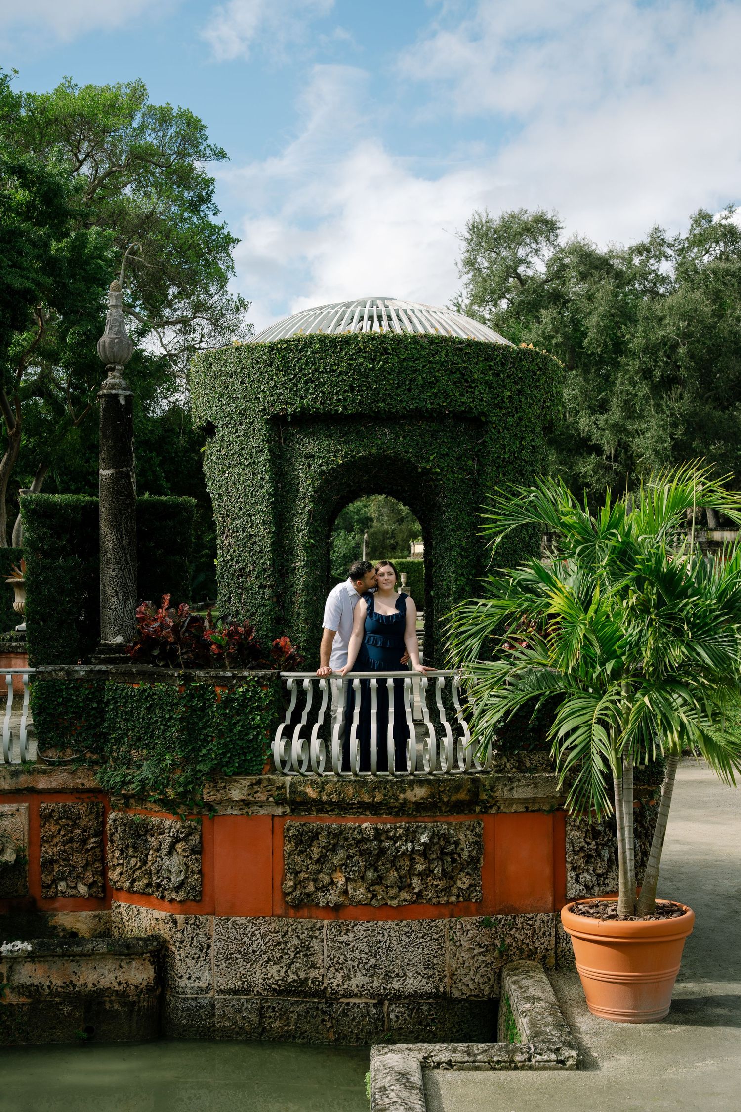 Lush garden courtyard with ivy-covered arches and stone balustrades at Vizcaya Gardens.