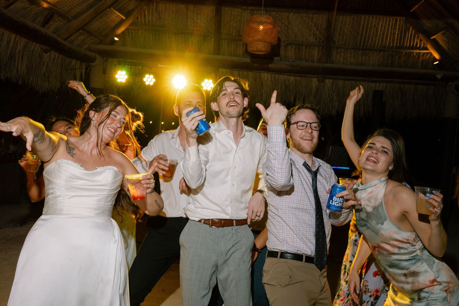 An image of a group of people, likely at a wedding reception, dancing and celebrating together.