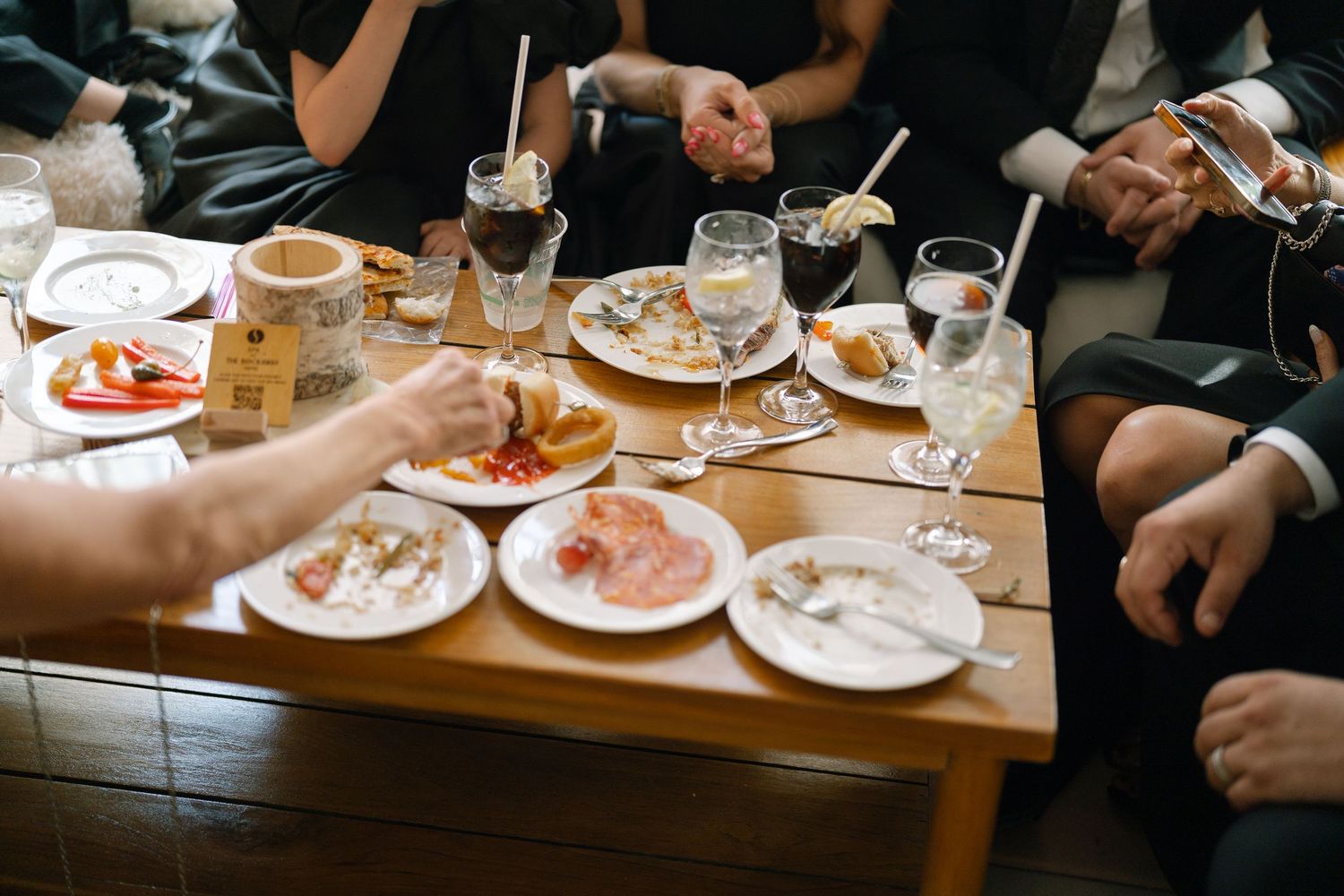 Close-up view of wedding reception dining table with appetizers and drinks being served.