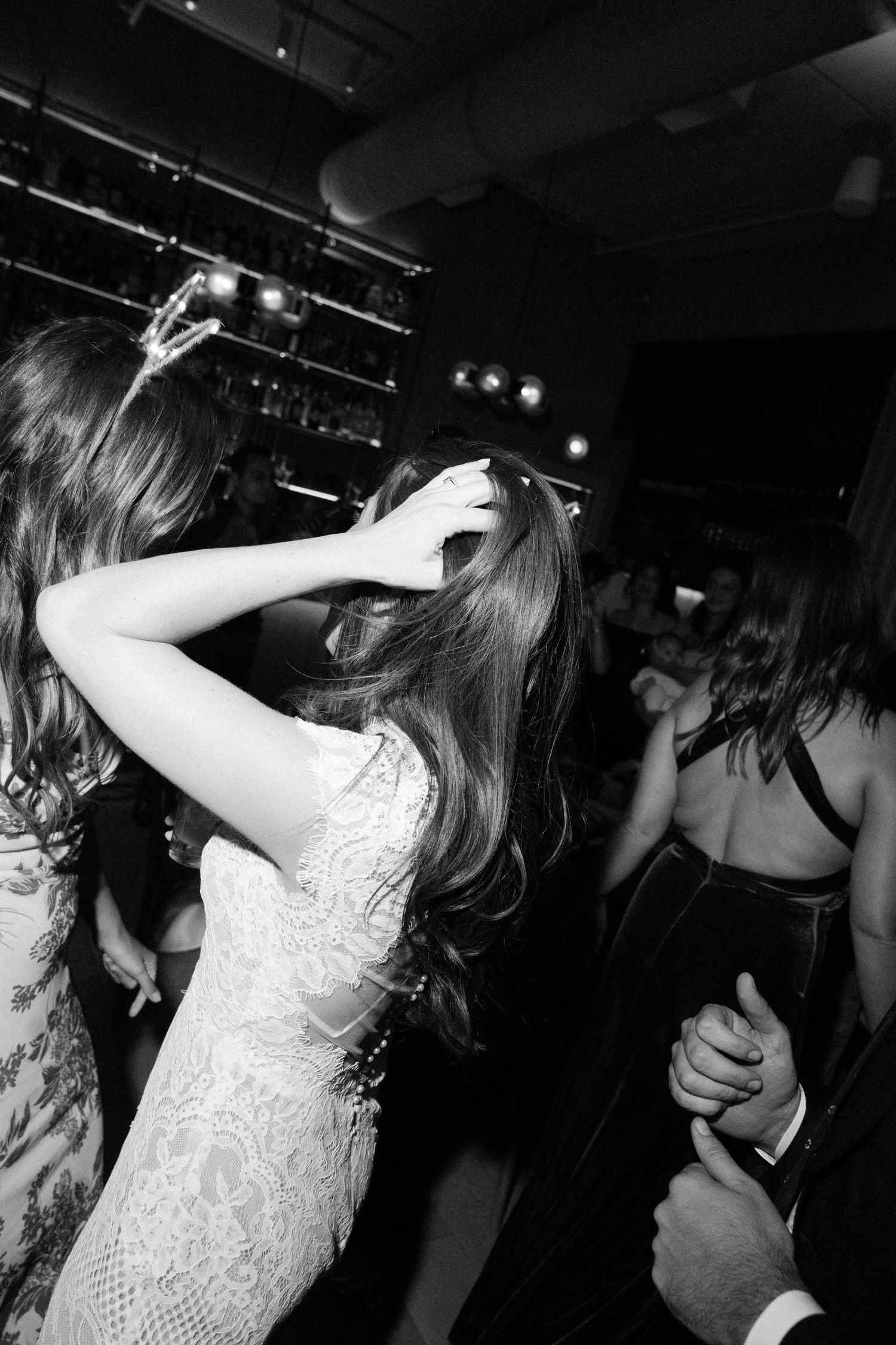 Black and white dance floor scene with person in white lace dress.